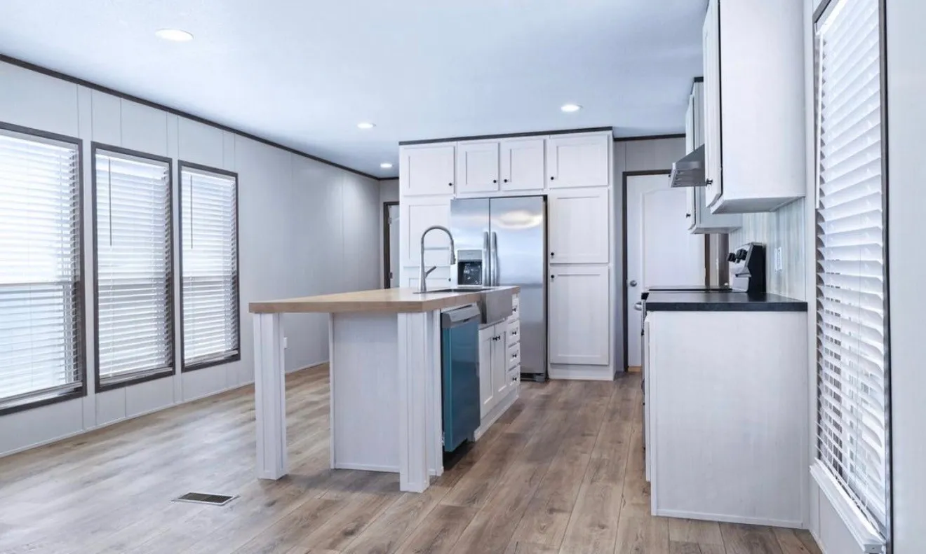 Open-concept kitchen with wood-finish flooring, white cabinetry, dark countertops, and stainless steel appliances