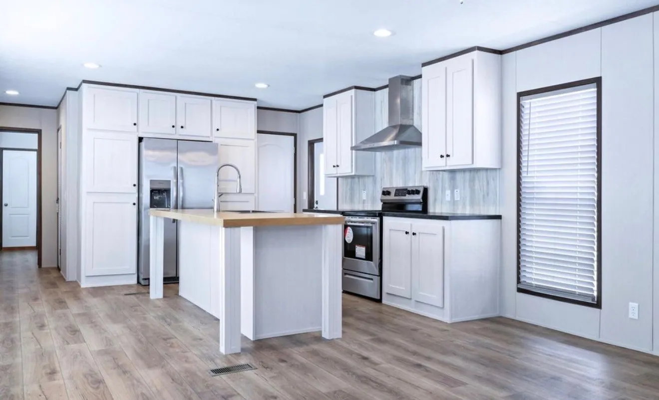Wood-finish flooring, white cabinetry, stainless steel appliances, central island with sink, and recessed lighting