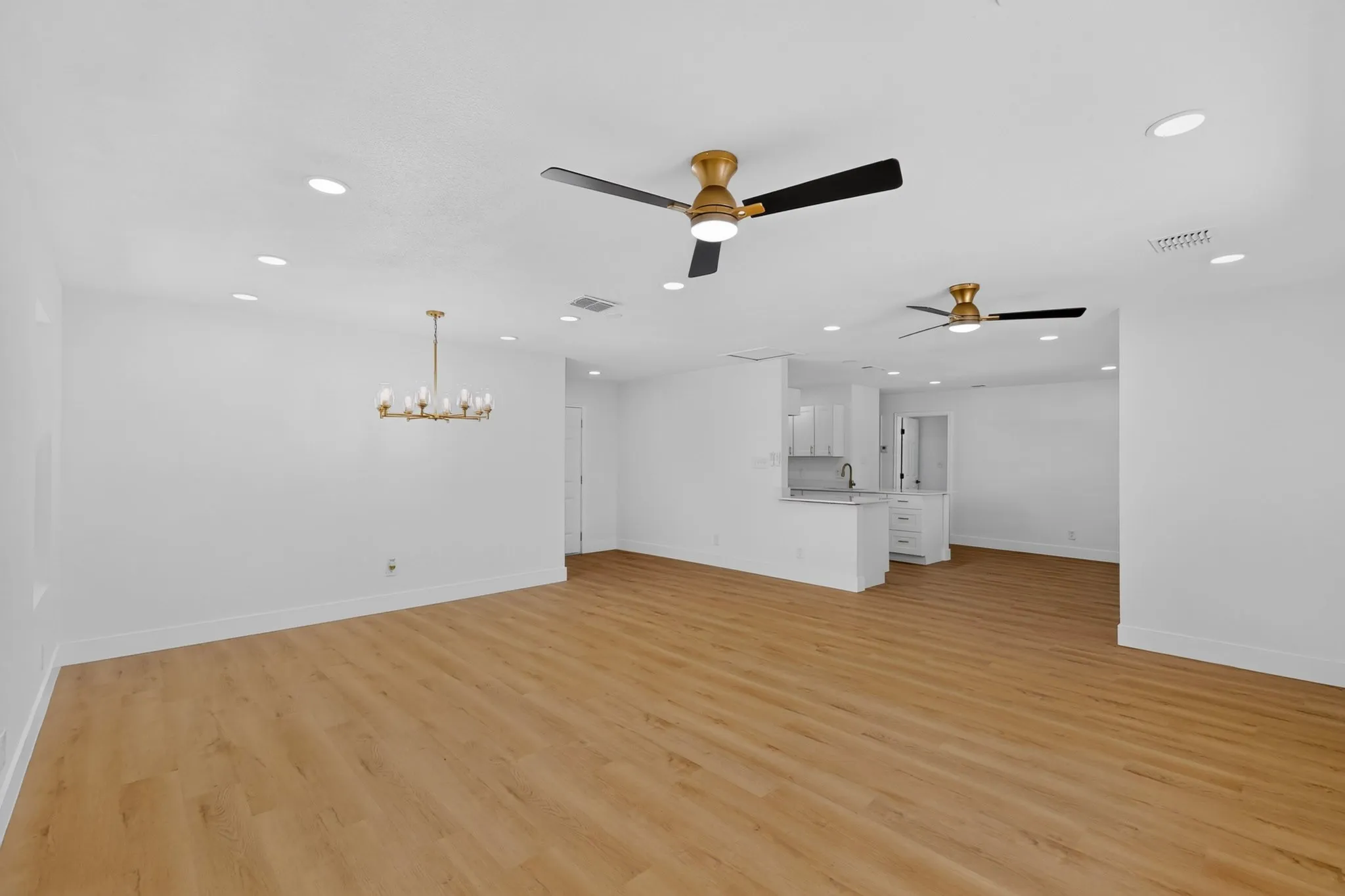 Open concept living space featuring wood-finish flooring, recessed lighting, and modern ceiling fans