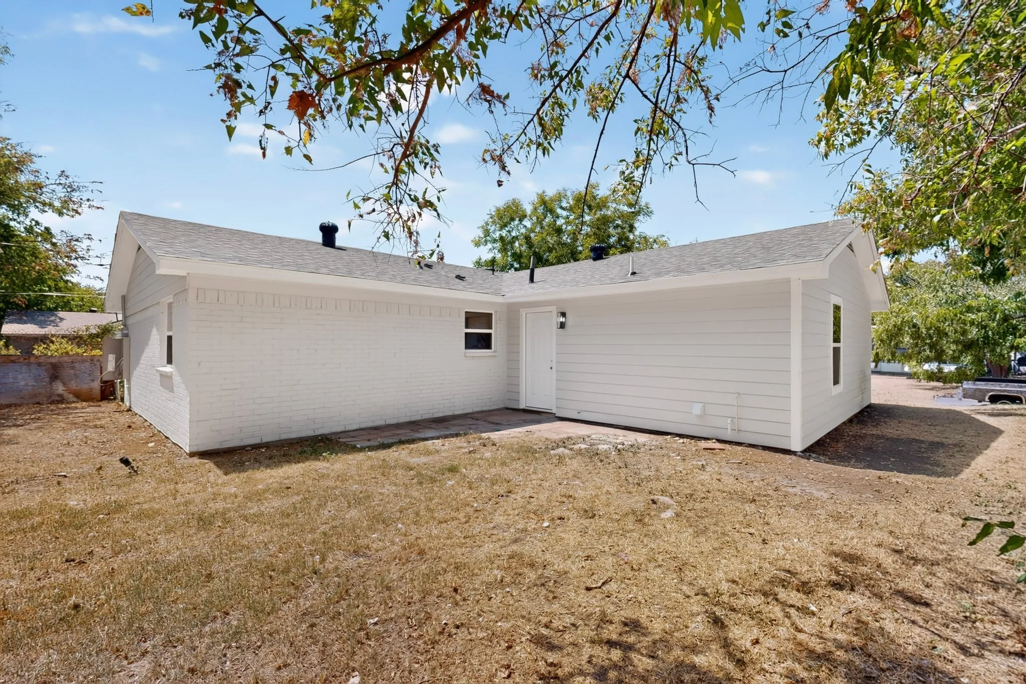 White painted brick exterior with horizontal siding accents