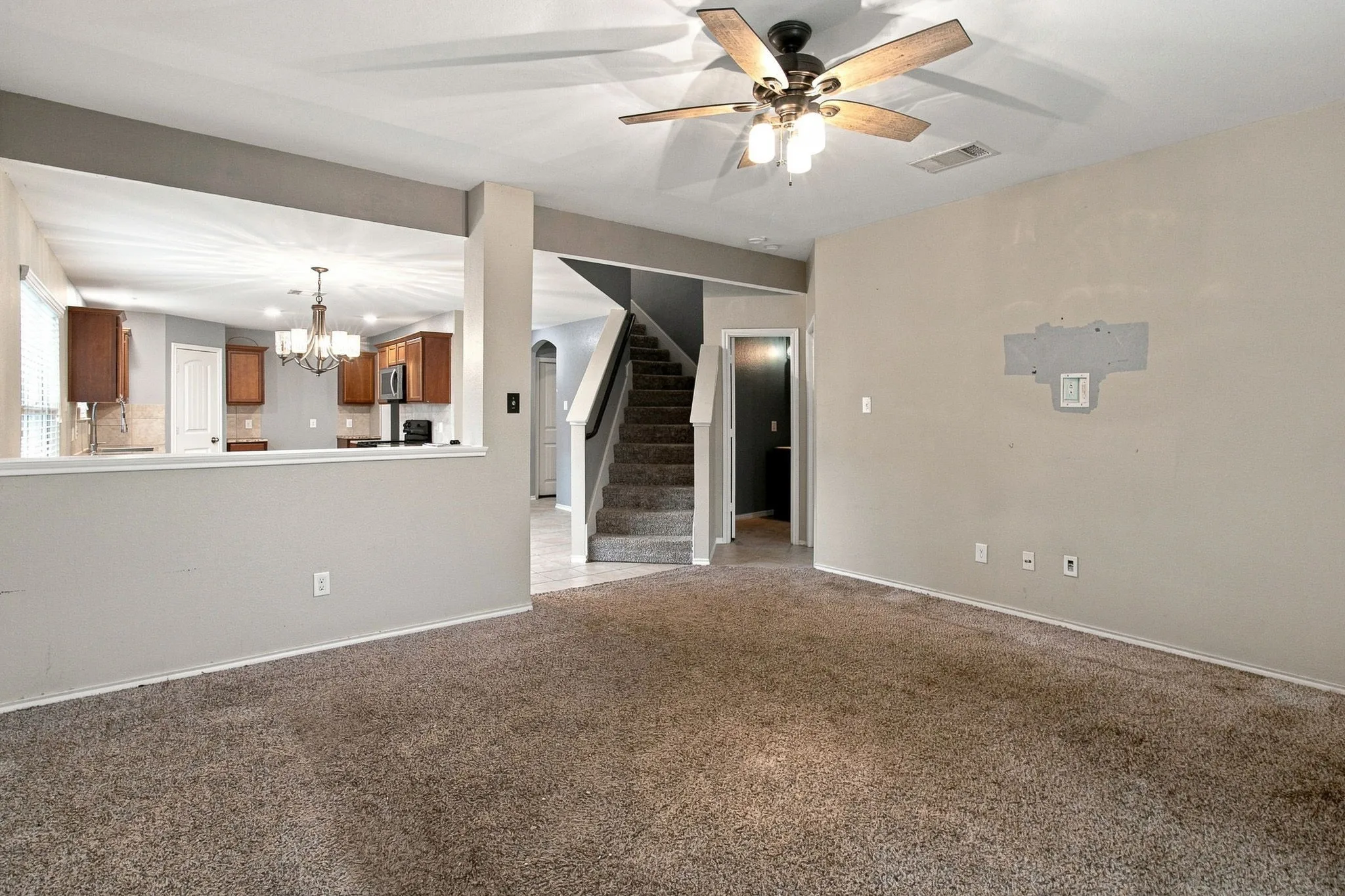 Carpeted living area with a ceiling fan light fixture