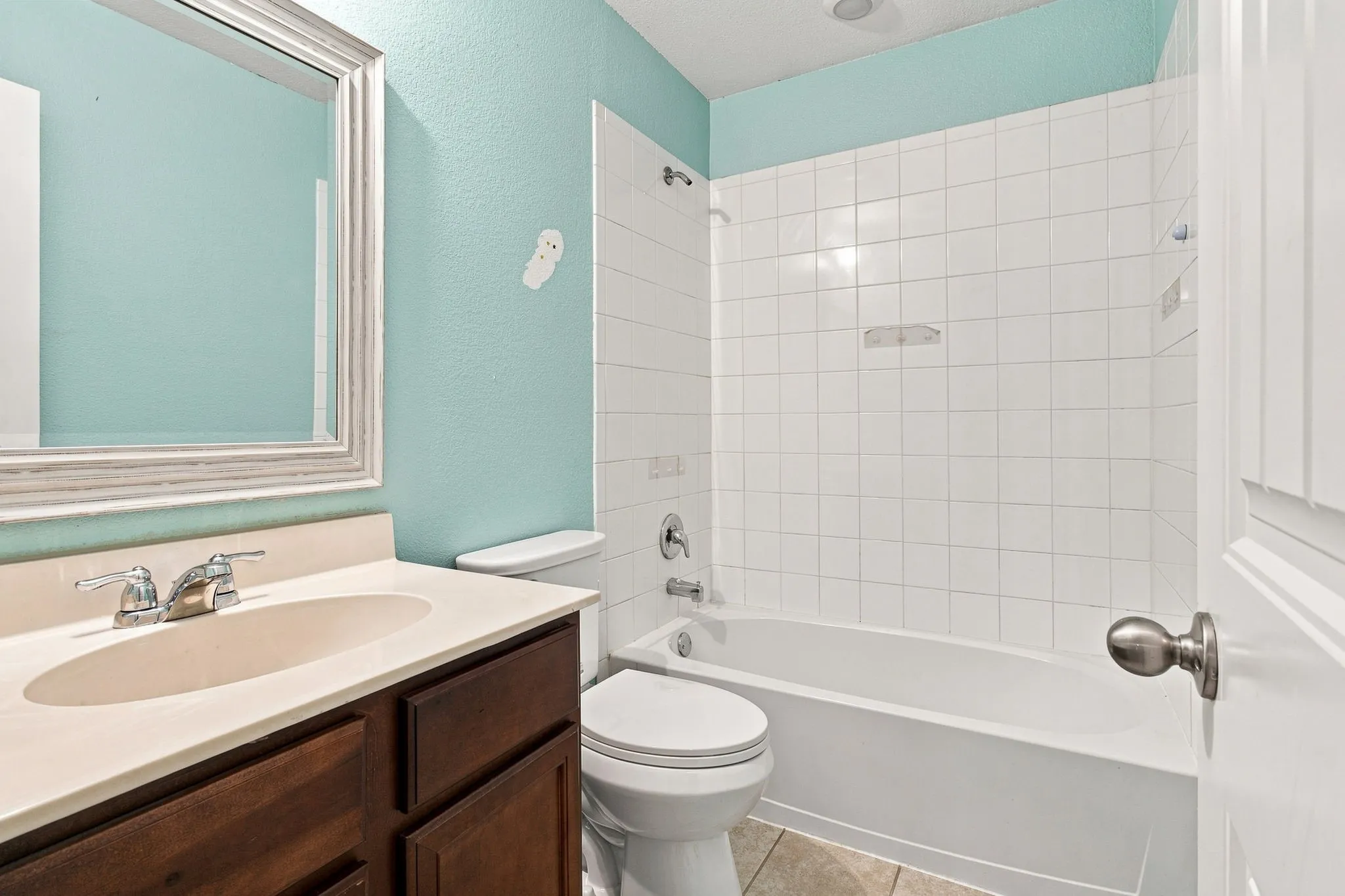 Vanity with integrated sink, chrome-finish faucet, and wood-finish cabinetry