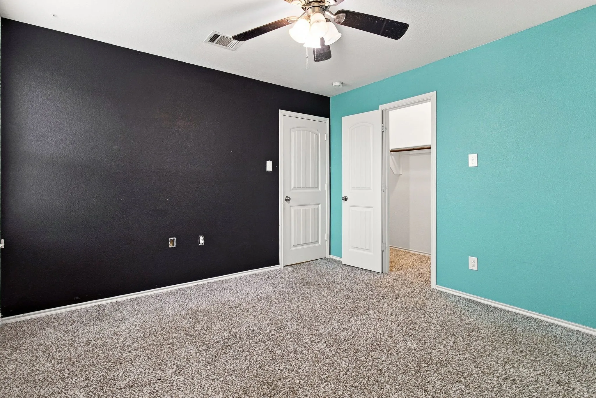 Carpeted flooring, ceiling fan with integrated lighting, two panel interior doors, and a built-in closet with shelving