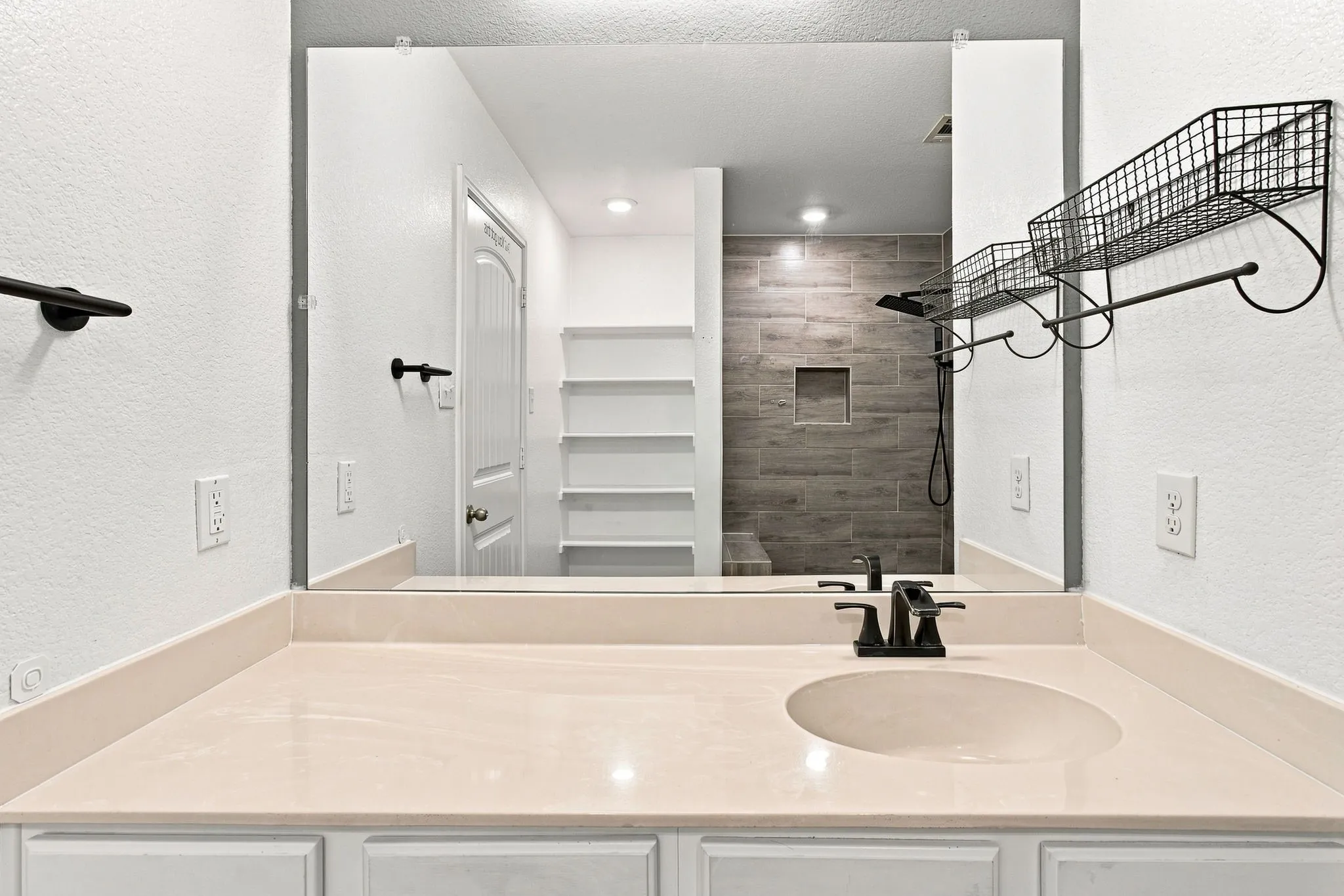 Vanity with integrated oval sink, countertop, and matte black faucet