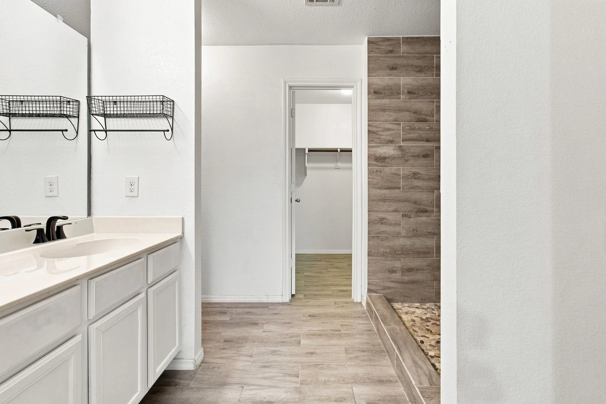 Bathroom vanity with white cabinetry and an integrated sink