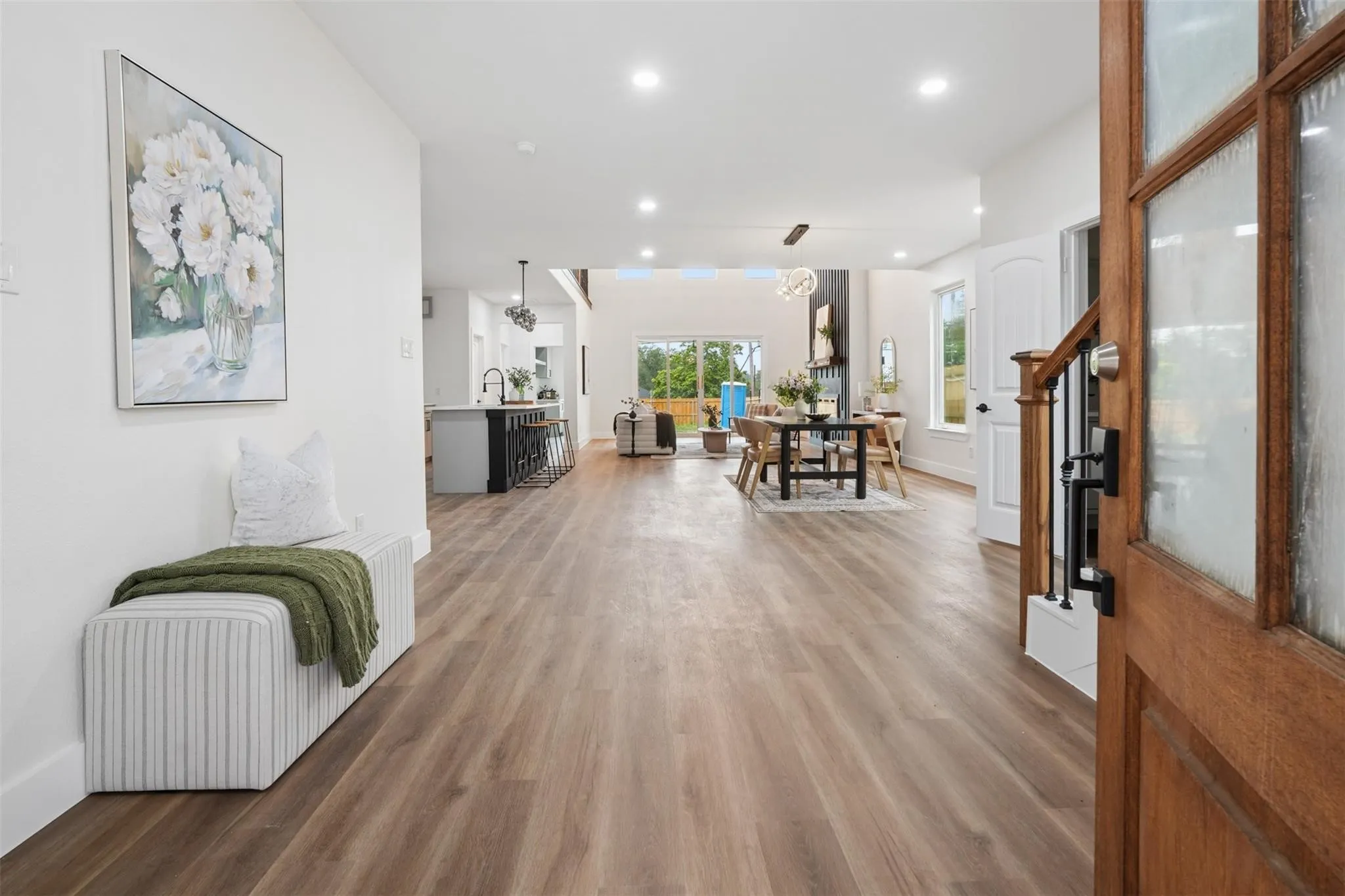 Wood-finish flooring throughout, recessed lighting, and a white interior