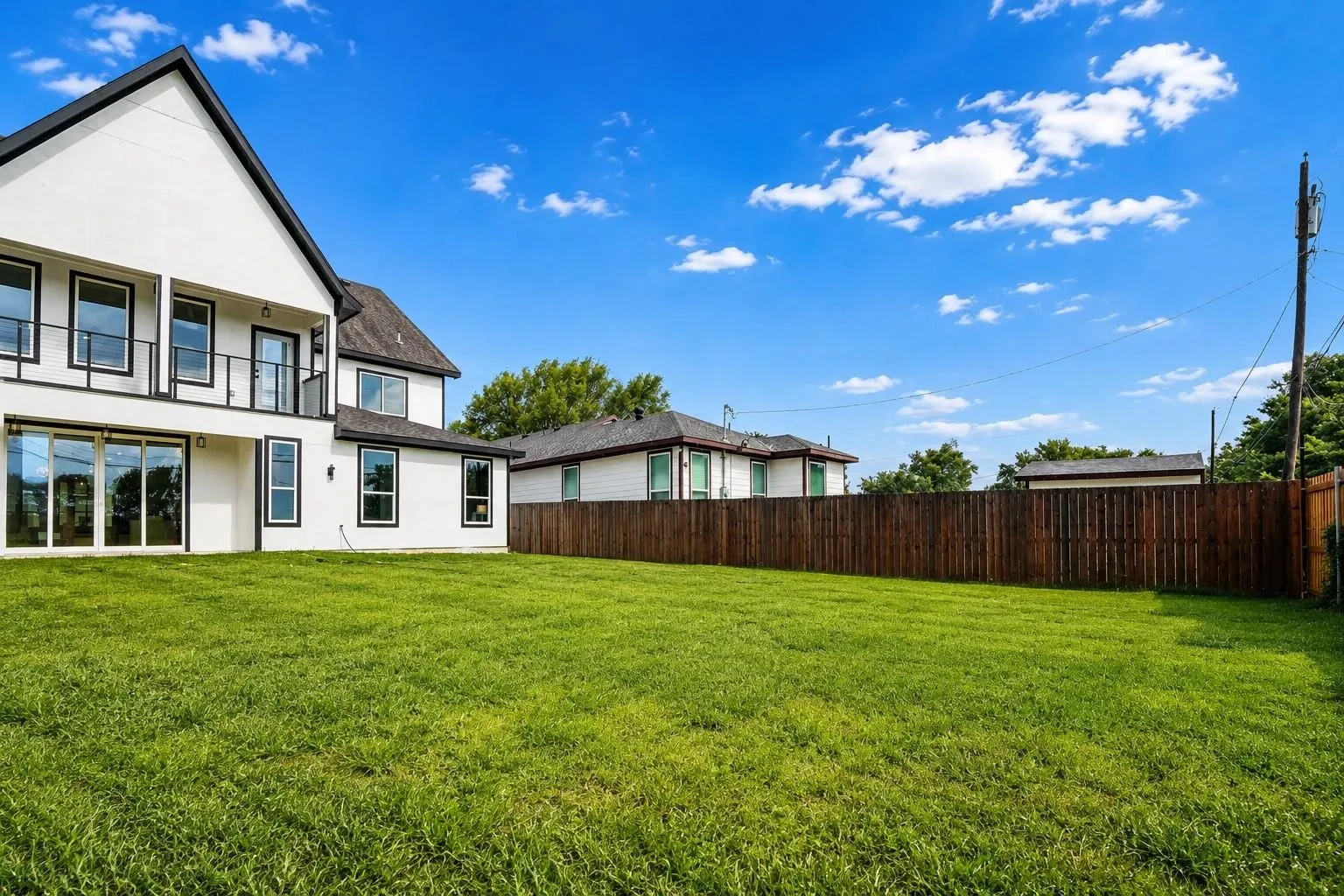Expansive rear lawn with a privacy fence