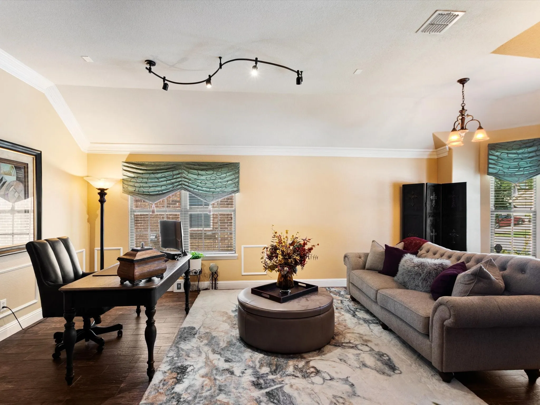 Tray ceiling with crown molding, track lighting, wood-finish flooring, and natural light