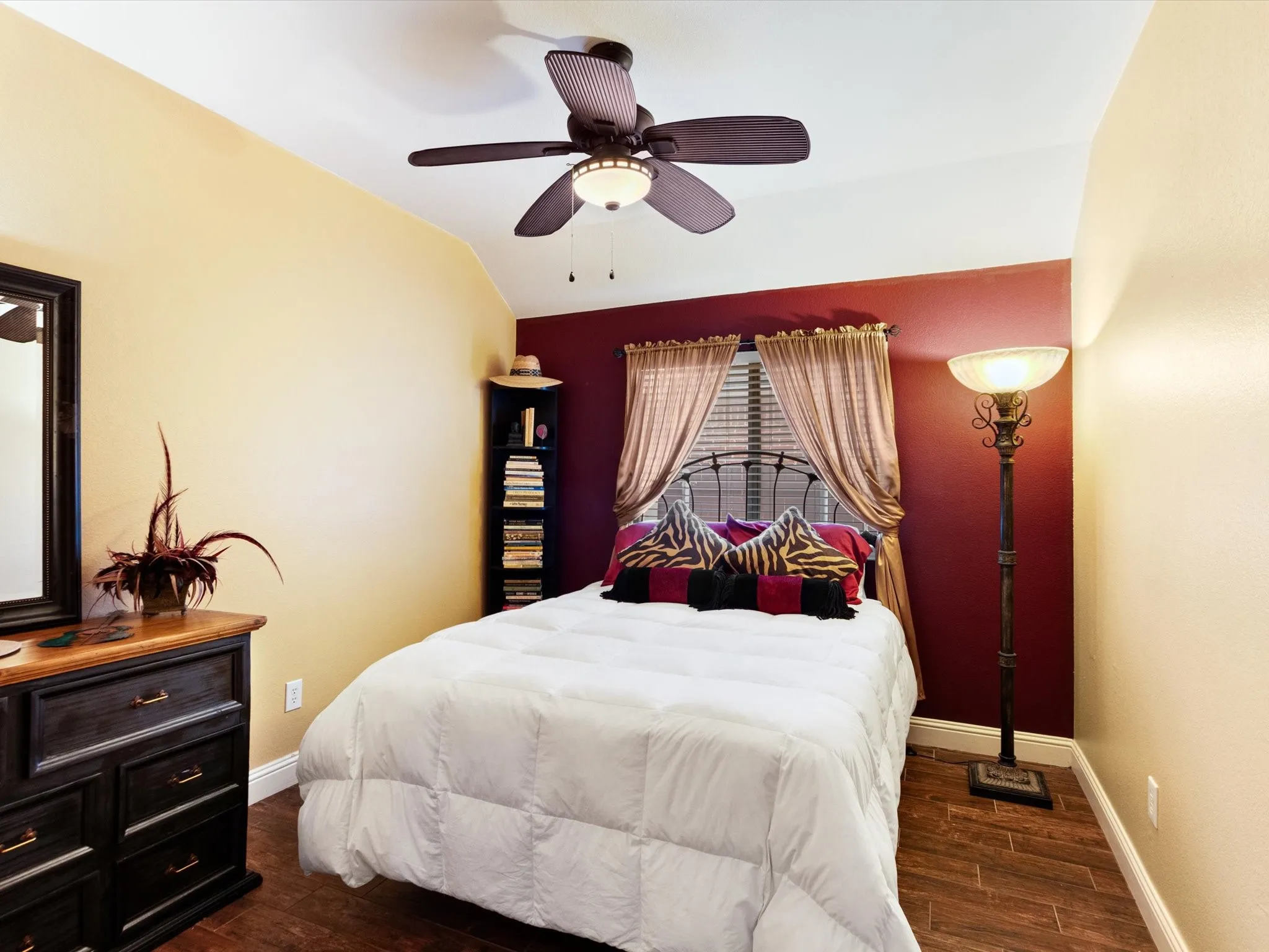 Recessed ceiling with a dark wood-finish ceiling fan, wood-finish flooring, and a window with blinds