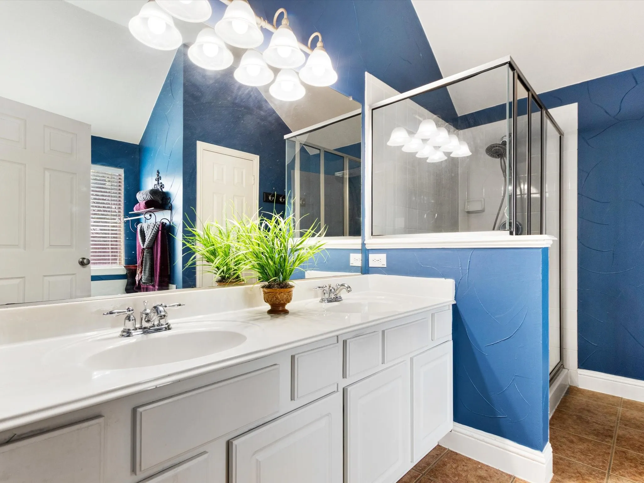Dual vanity with white cabinetry, integrated sinks, and chrome fixtures