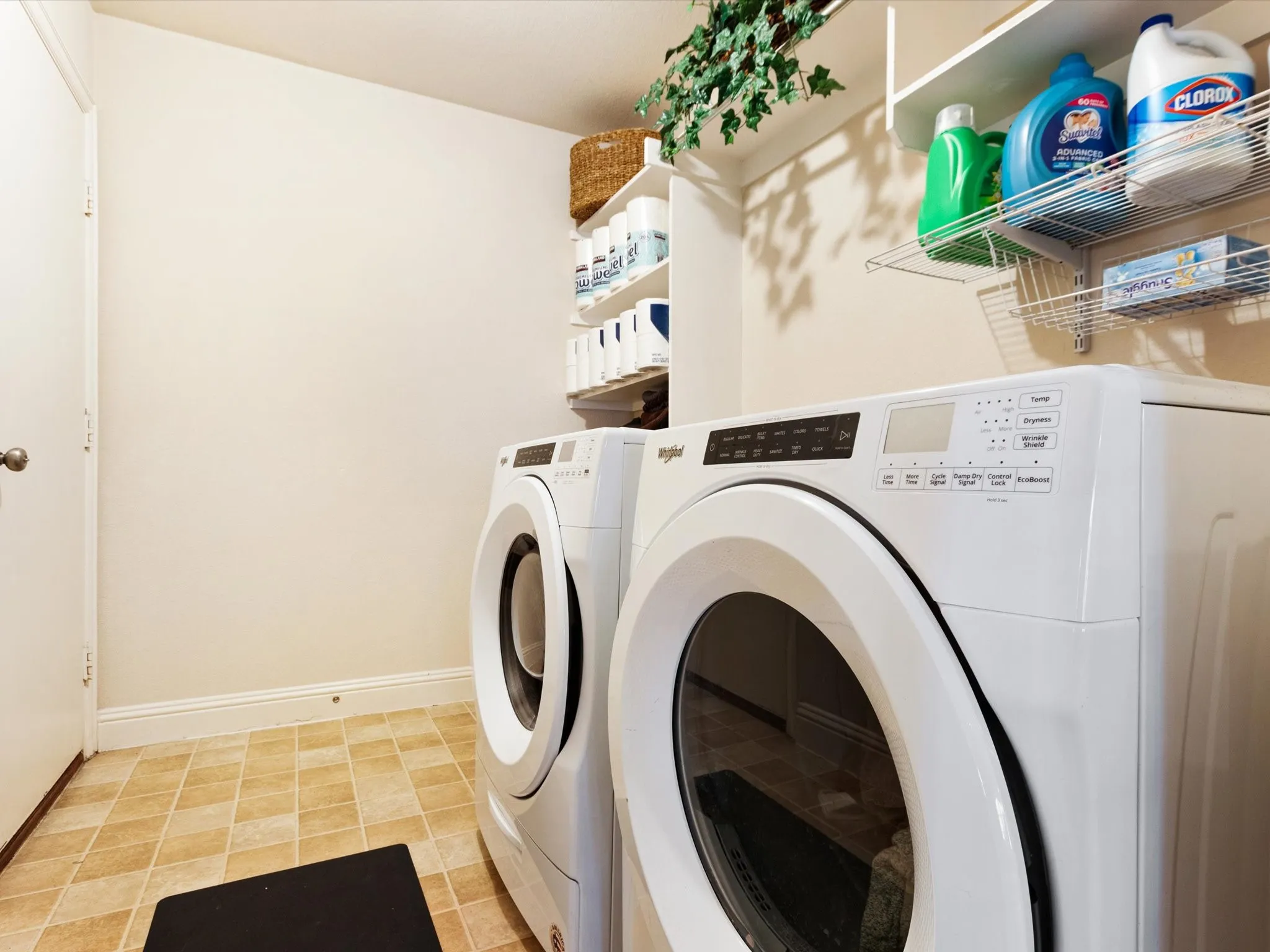 Laundry area featuring tile flooring and integrated wall shelving