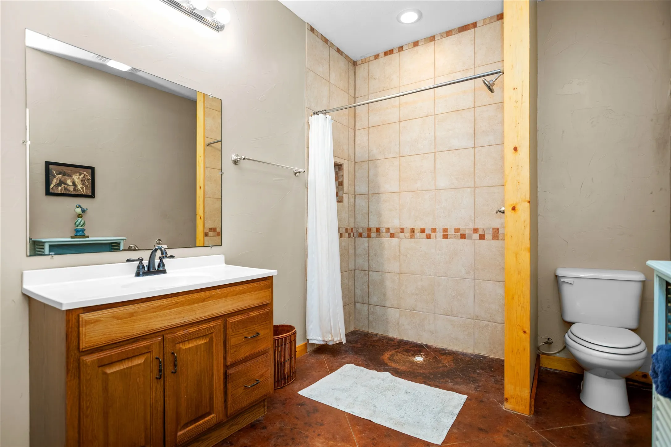Guest quarters bathroom with vanity, a shower stall, and tile floors