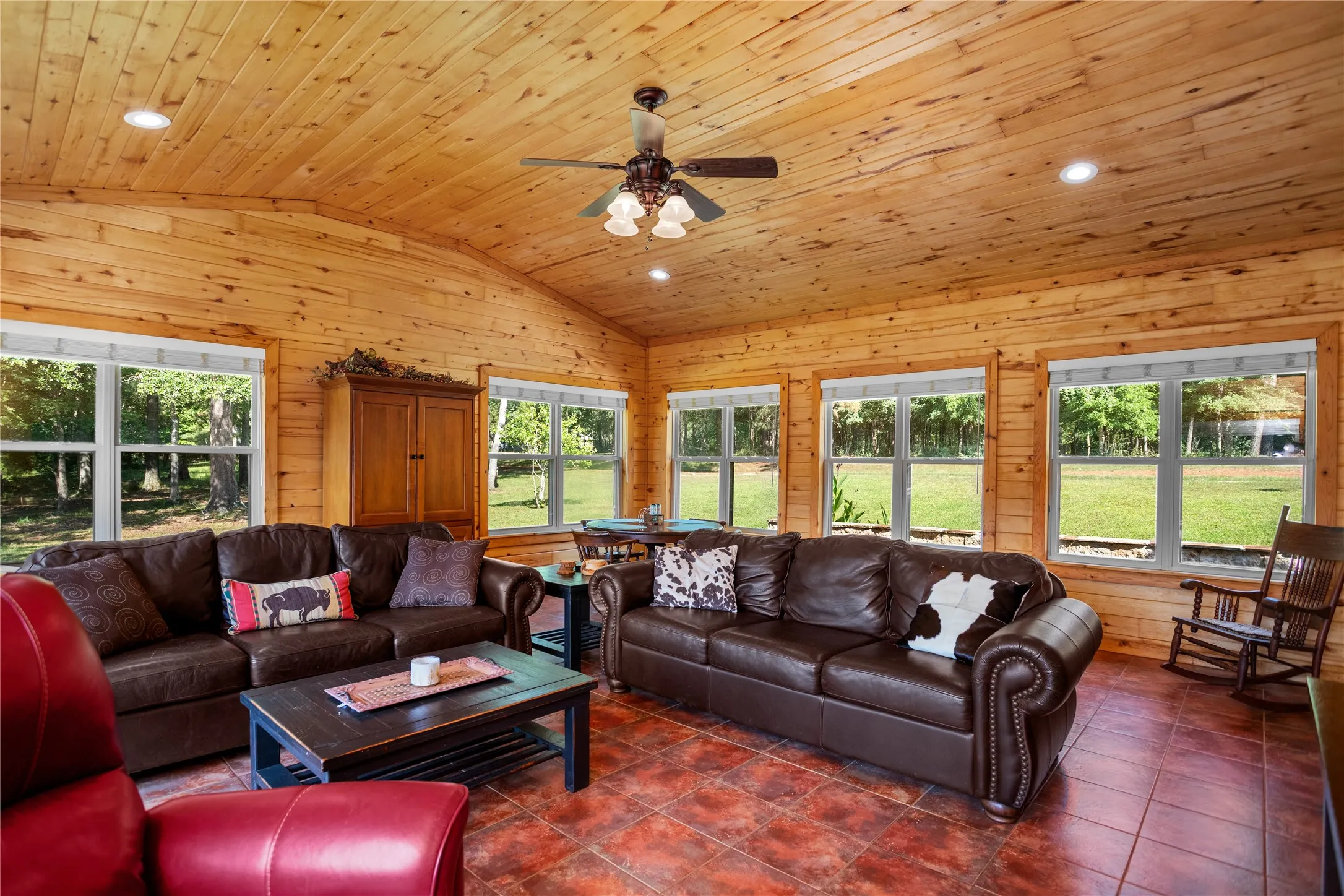 Family room area featuring vaulted ceiling, healthy amount of natural light, recessed lighting, aspen wood walls and ceiling, and tile flooring