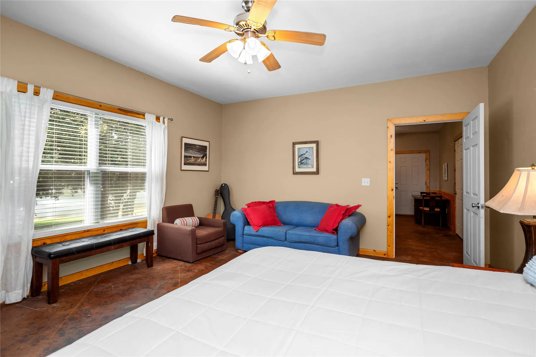 Guest quarters bedroom featuring ceiling fan, tile floors, and lake view
