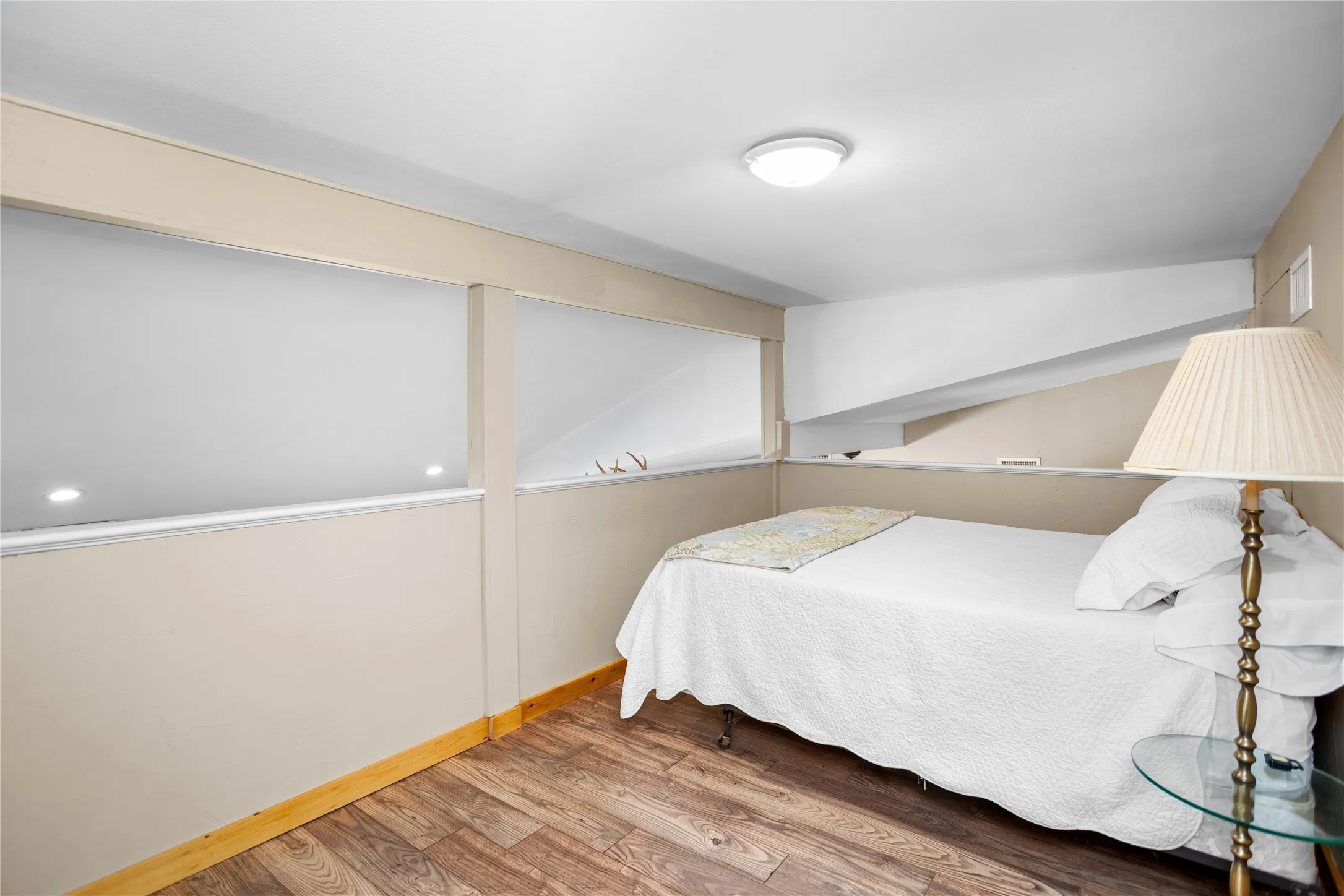 Loft with wood-style finished floors and baseboards