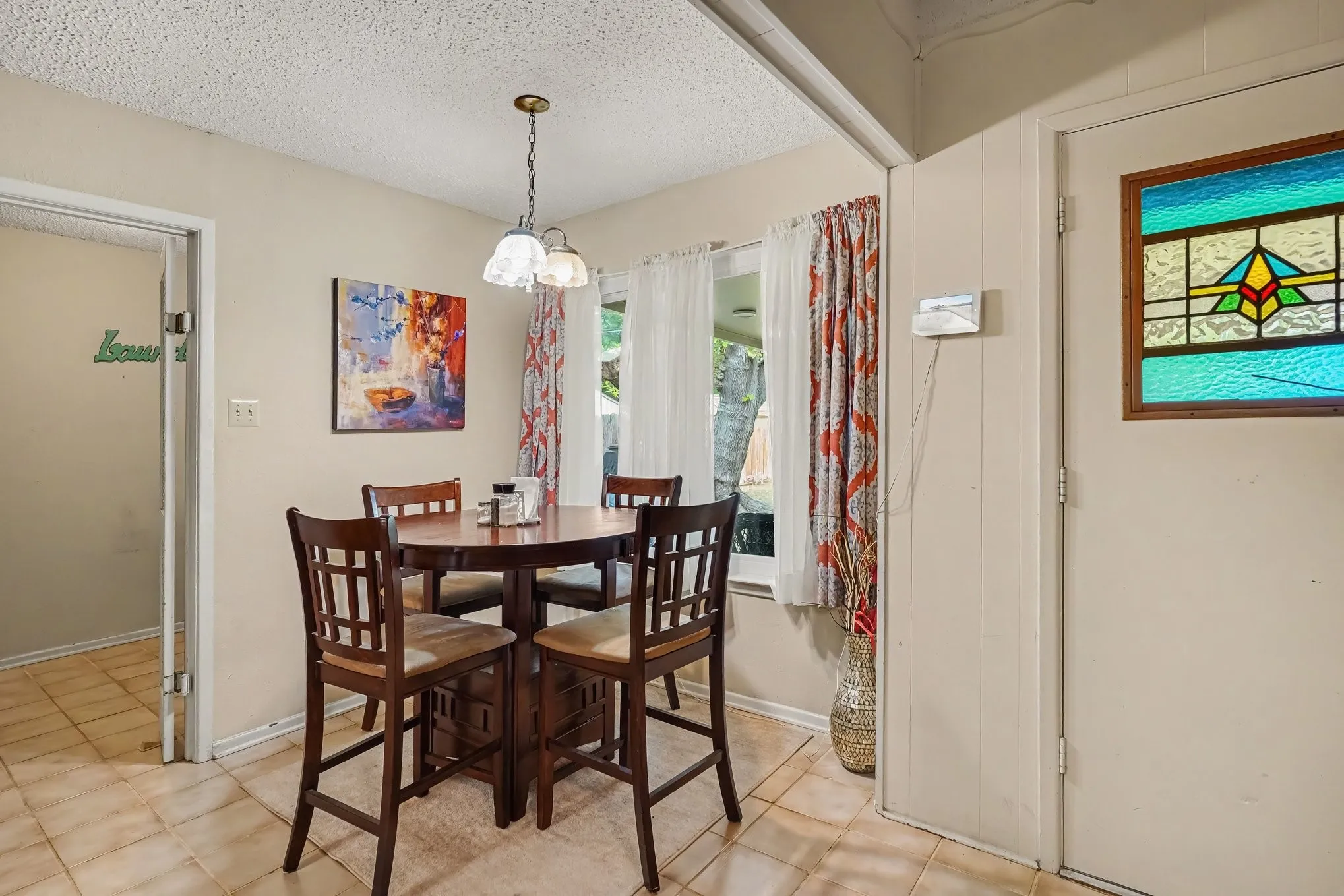 Recessed window, ceiling-mounted light fixture, tile flooring, interior wall paneling, and frosted glass door