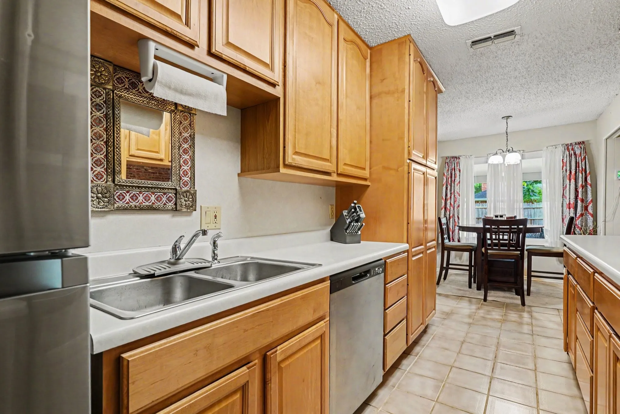 Kitchen featuring abundant wood cabinetry, a dual basin stainless steel sink, and a built-in dishwasher