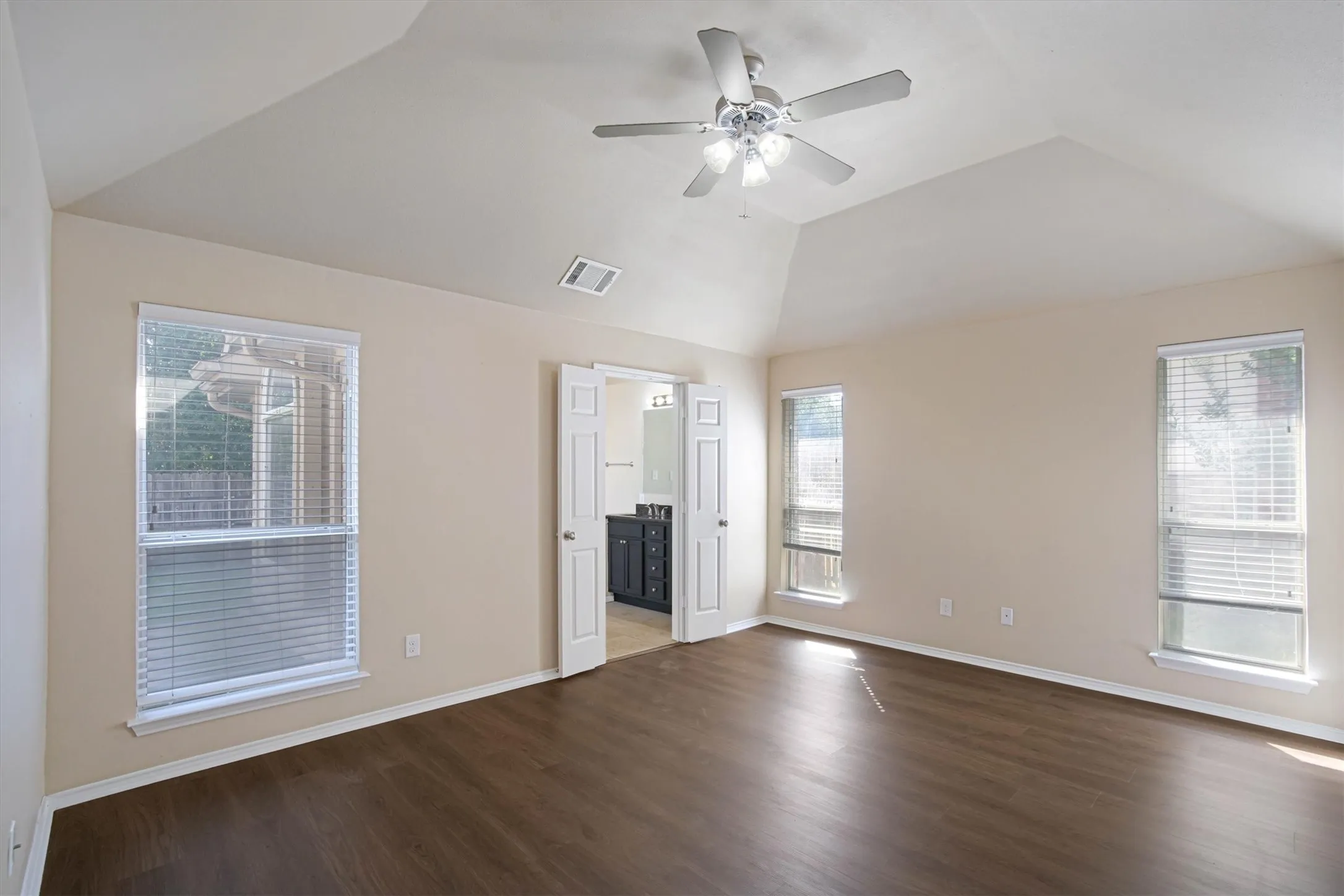 Spacious primary suite with ensuite bathroom and newly installed luxury vinyl plank flooring.