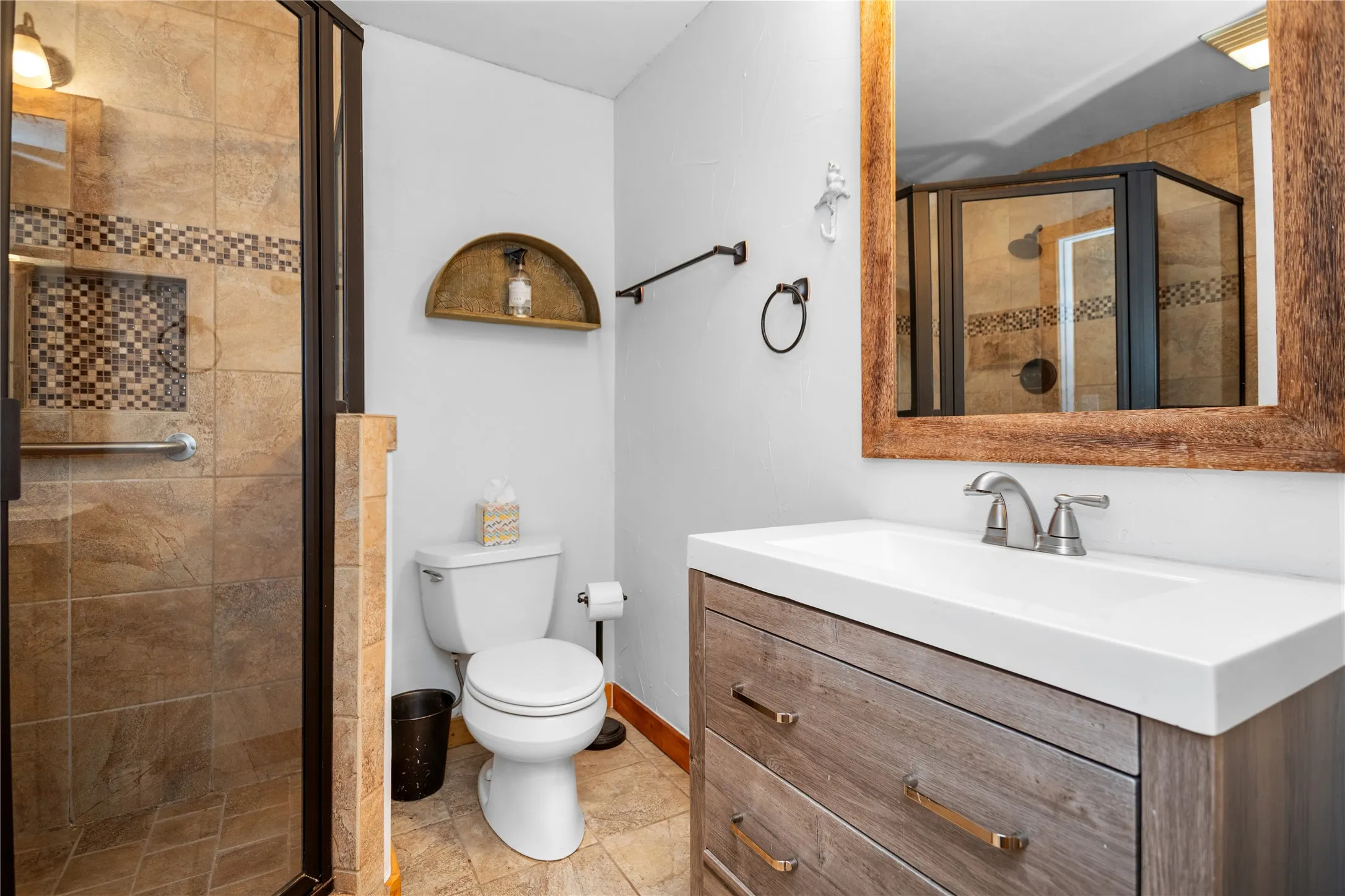 Full bathroom featuring vanity, a stall shower, and tile floors