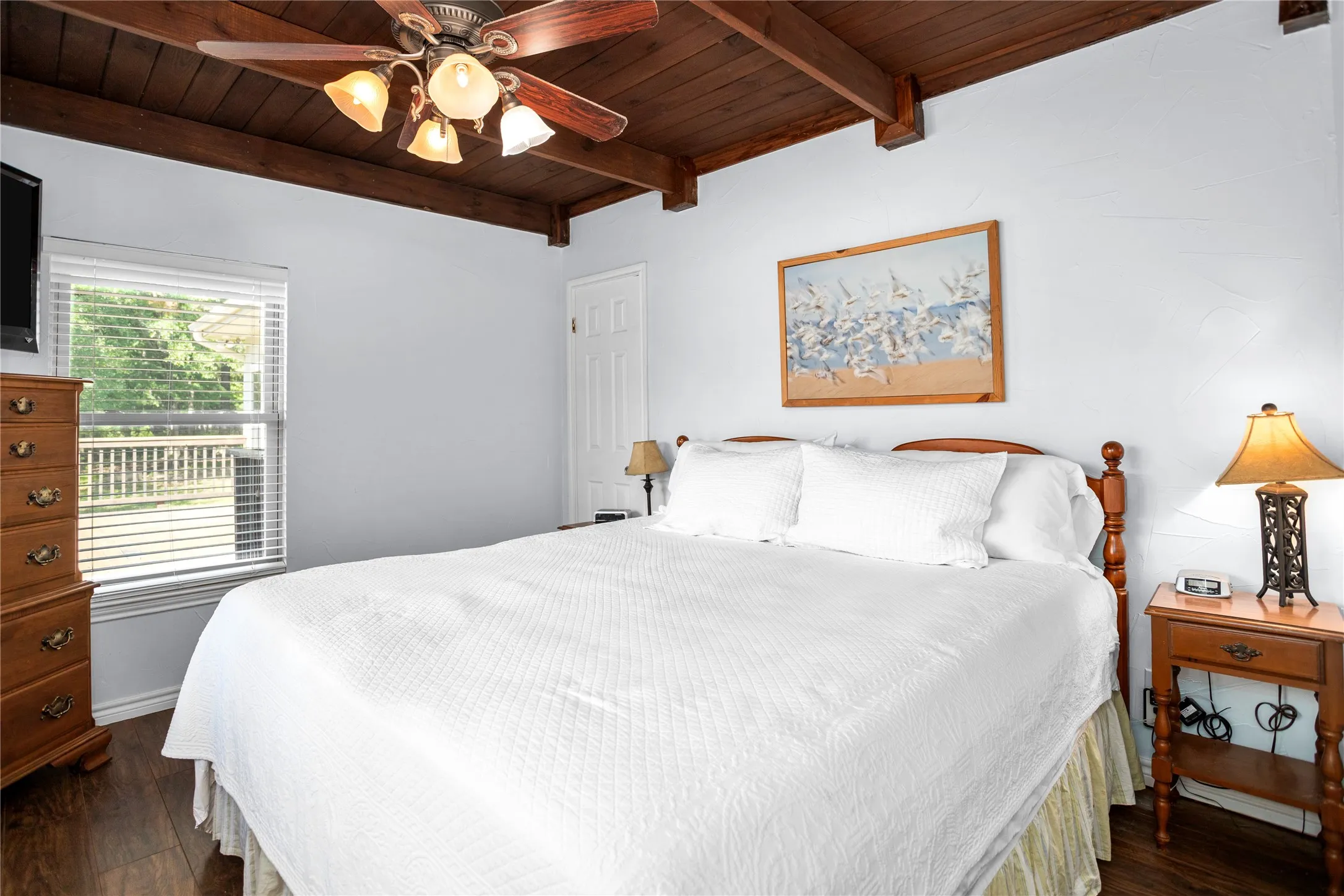 Primary Bedroom featuring a wood ceiling with exposed beams, a ceiling fan, and dark wood-style flooring