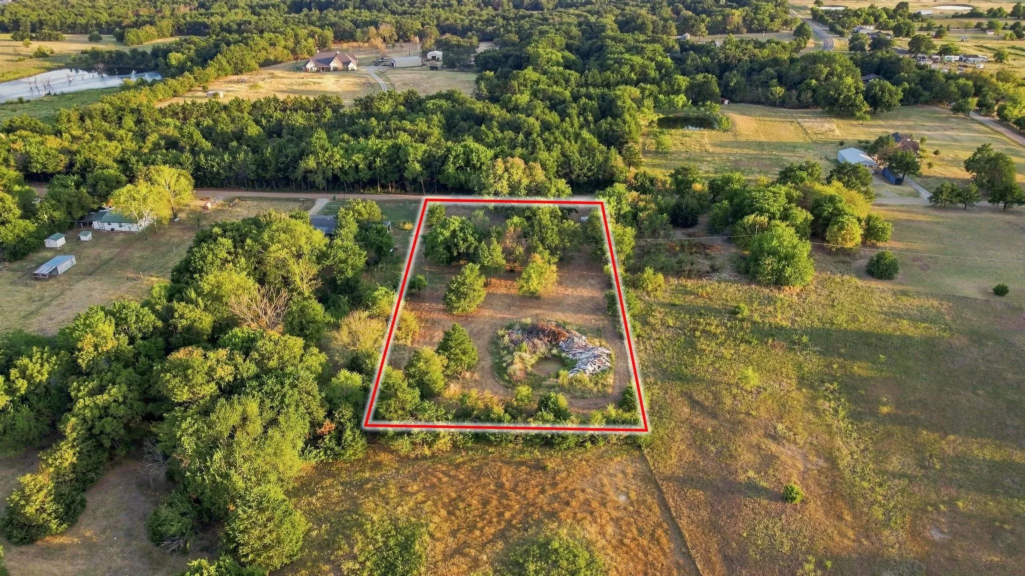 Expansive undeveloped lot featuring mature trees and partial clearing