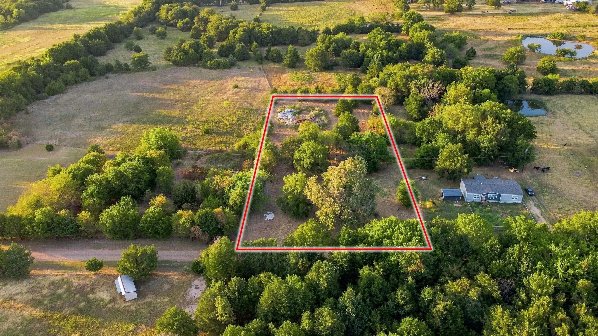 Wooded acreage with a visible residential structure