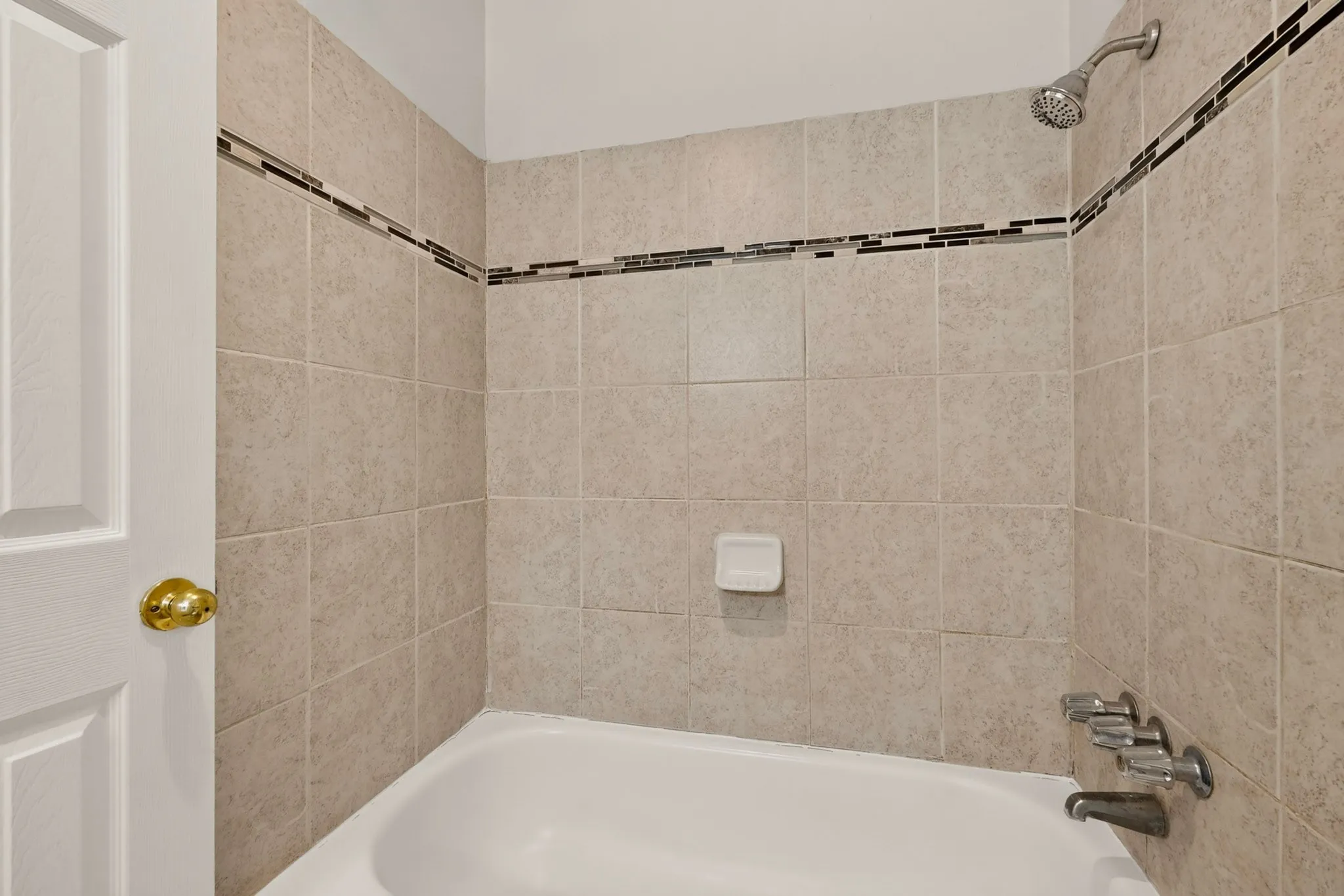 A bright bathroom with an alcove tub against light-colored walls, creating a serene atmosphere.
