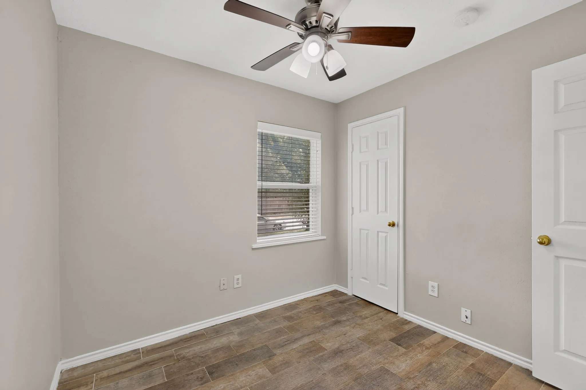 A well-lit second bedroom featuring a ceiling fan, closet and a window that invites sunlight in.