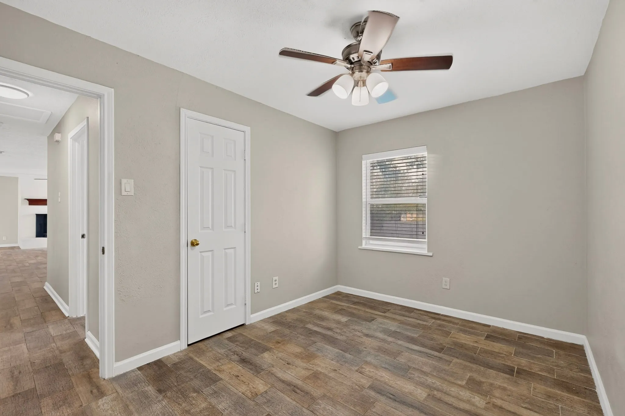 A well-lit third bedroom featuring a ceiling fan, closet and a window letting in natural light.
