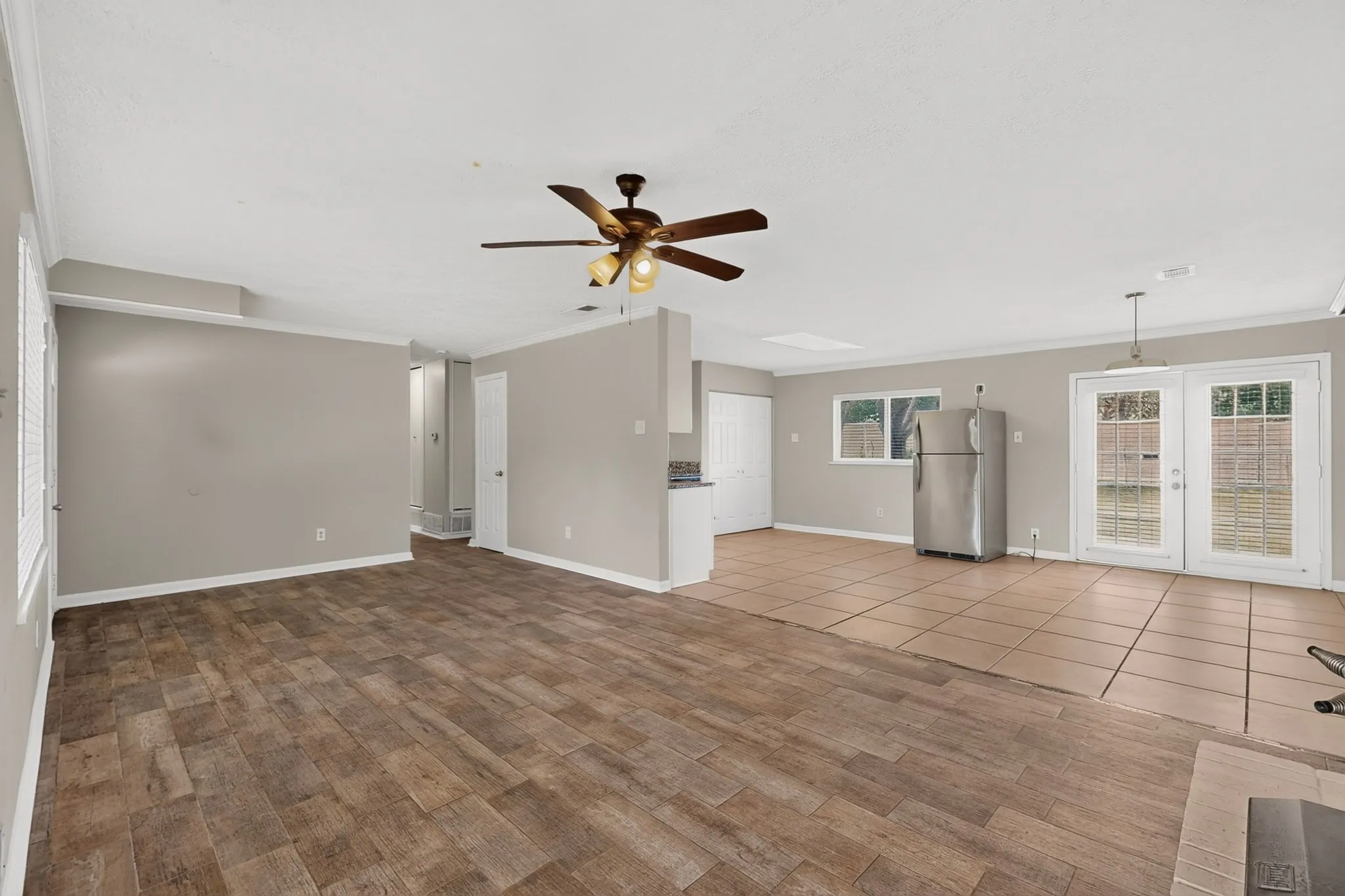 A bright living room featuring hardwood floors and a ceiling fan, ready for new furnishings and decor.