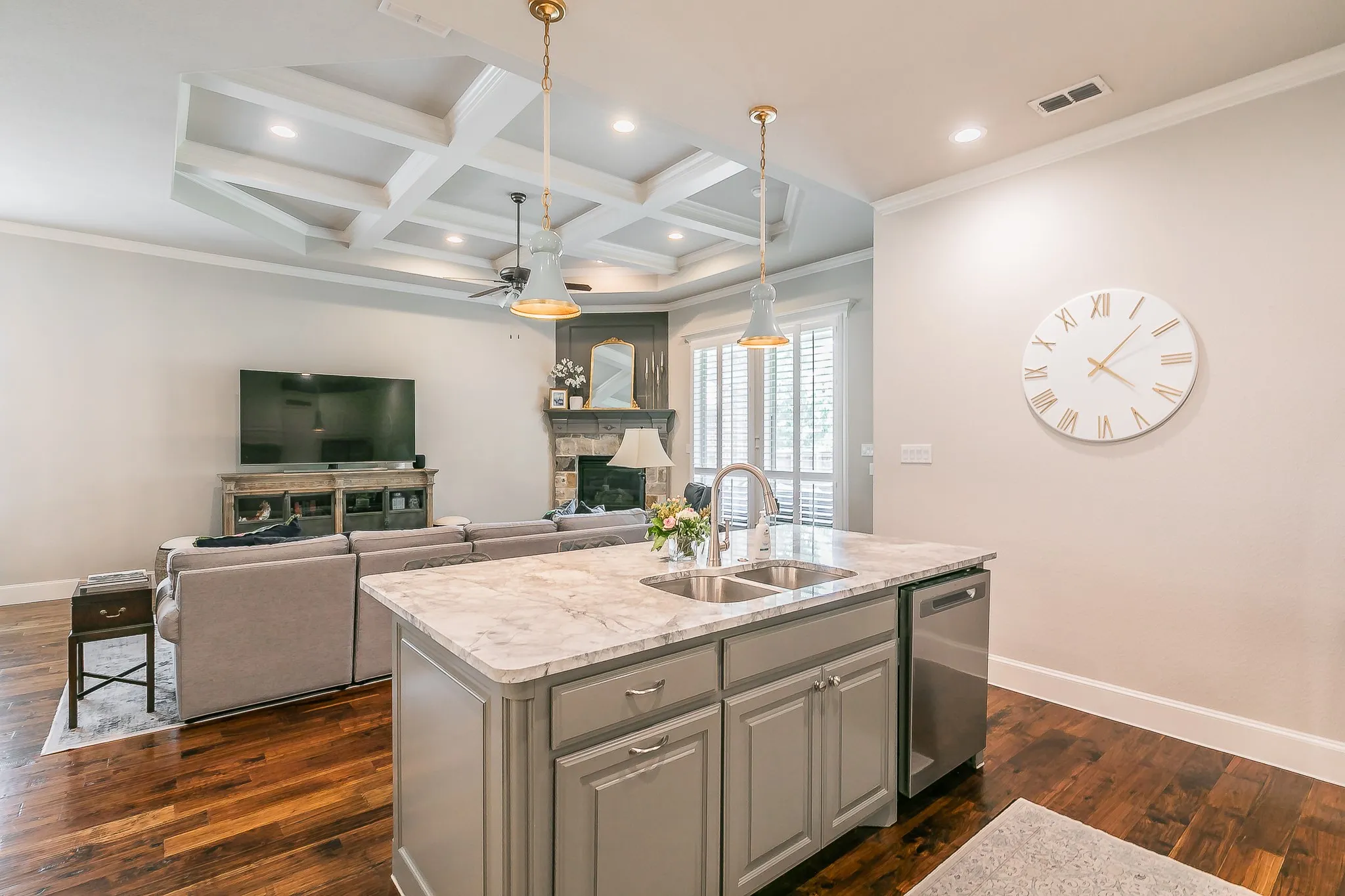 Kitchen island with an undermount double-basin sink, stainless steel dishwasher, and pendant lighting