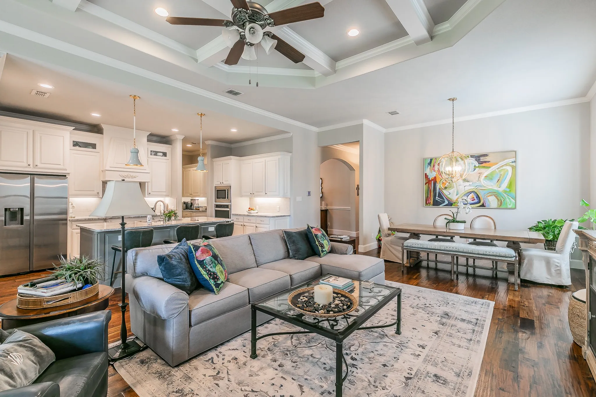 Tray ceiling with a ceiling fan, recessed lighting, and wood flooring