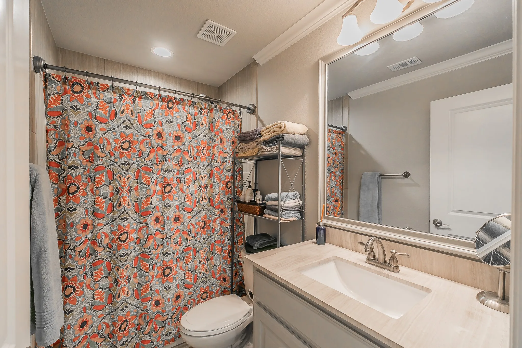 Vanity with integral sink, brushed nickel faucet, and a large framed mirror