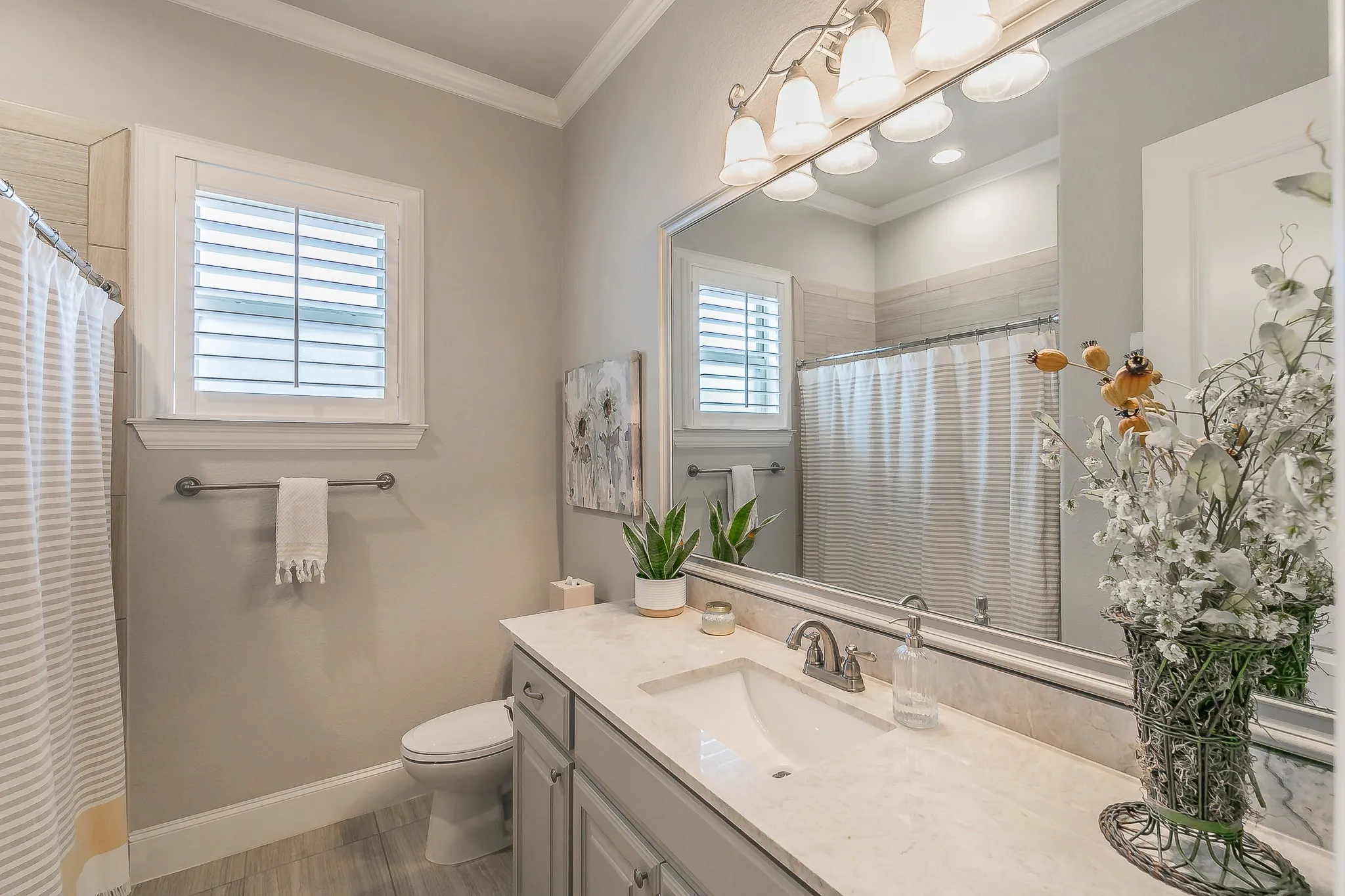 Bathroom featuring a single vanity with a solid surface countertop, an undermount sink, and wood flooring