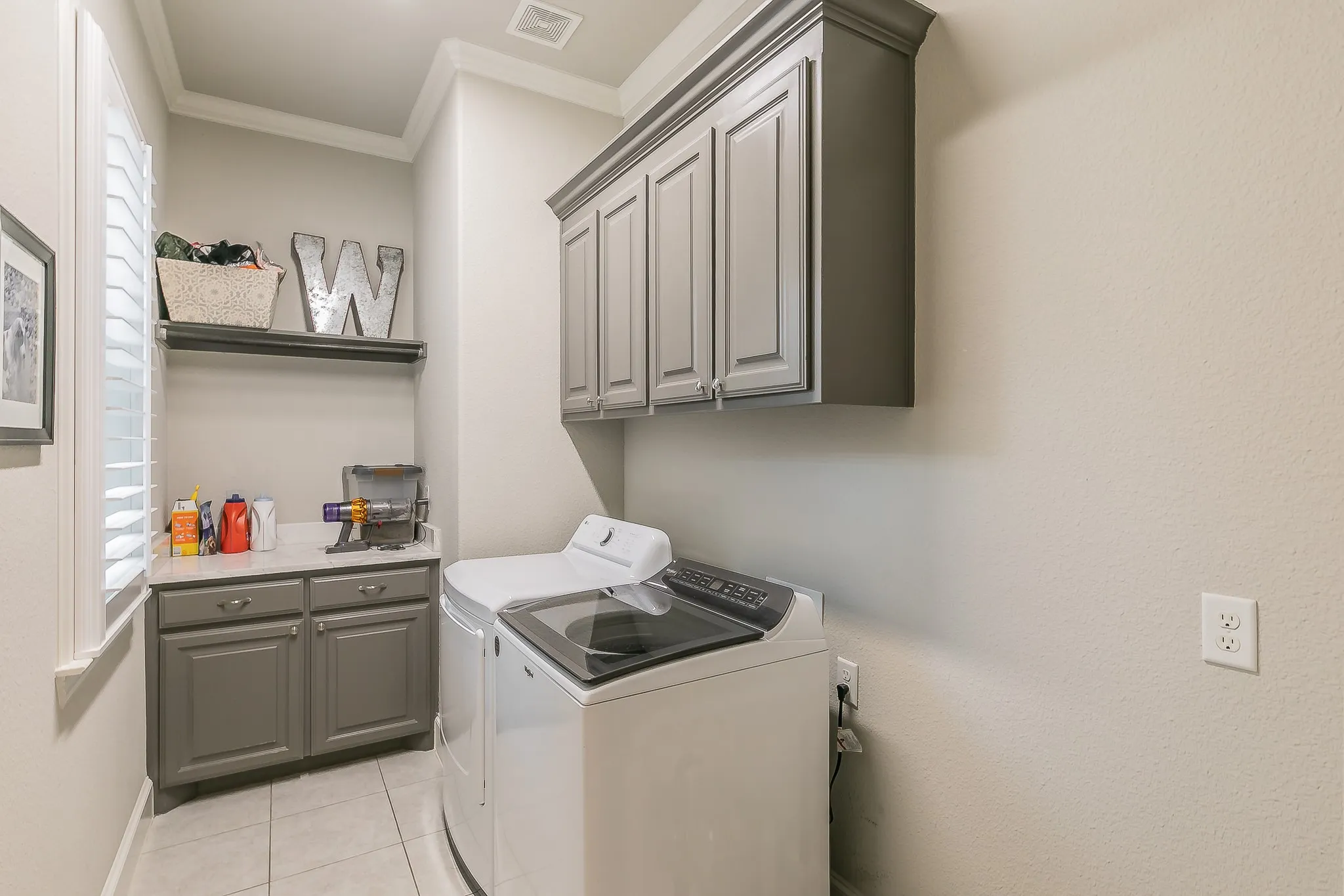 Laundry room featuring gray shaker-style cabinetry, a white countertop, and tile flooring