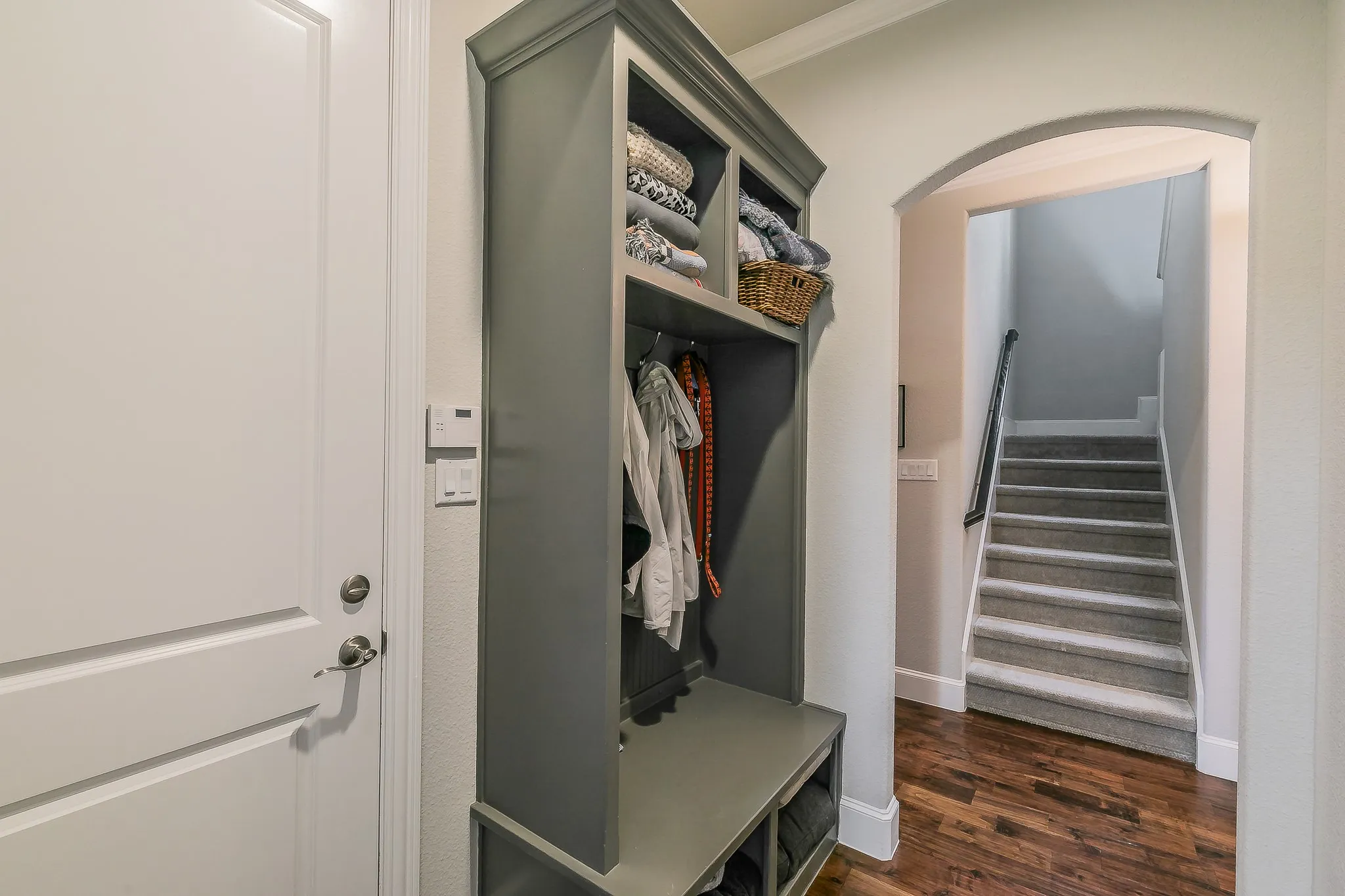 Built-in storage cabinet with hanging space, bench seating, and upper shelving