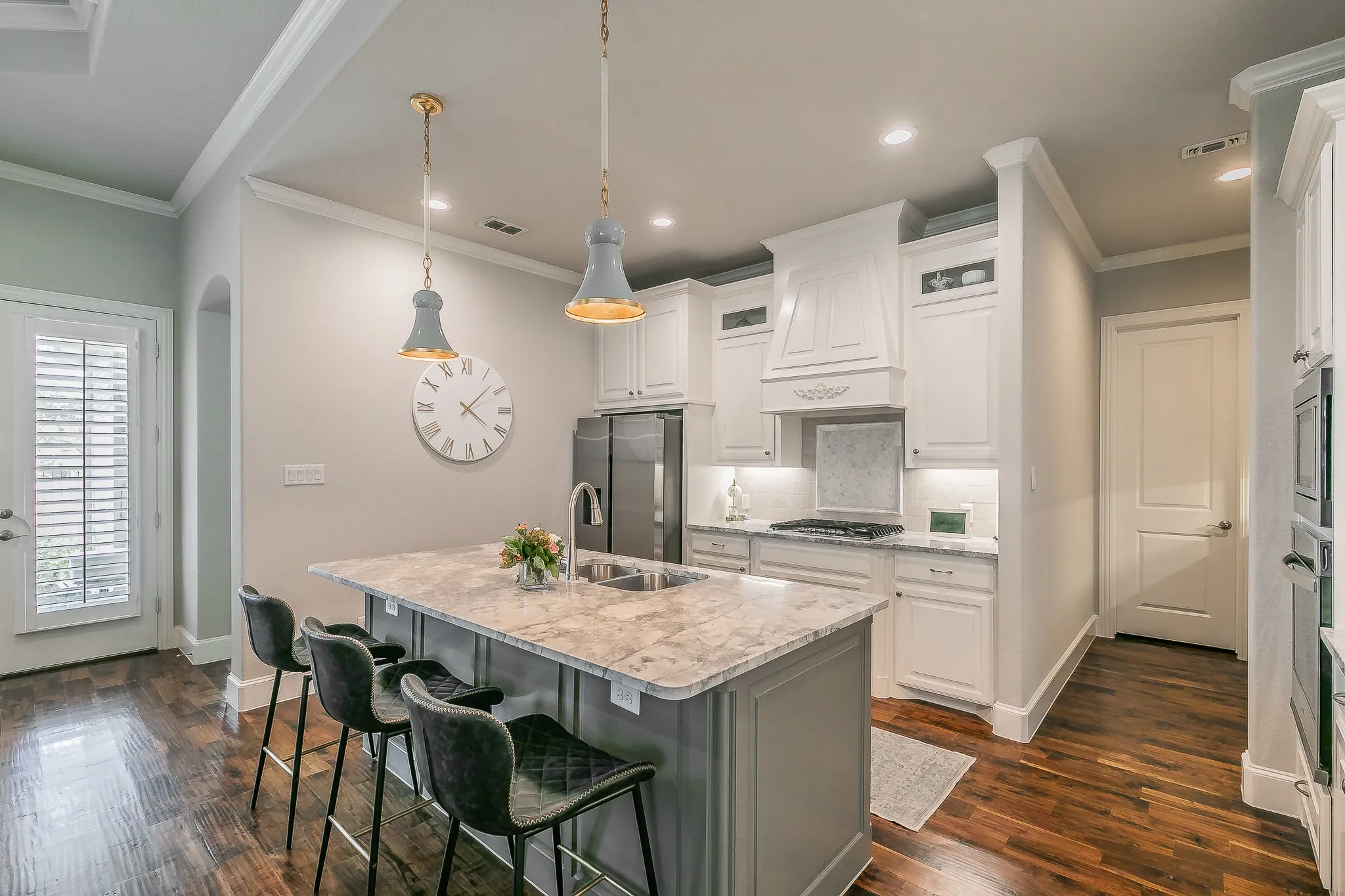 Kitchen featuring a center island with sink, white shaker cabinetry, recessed lighting