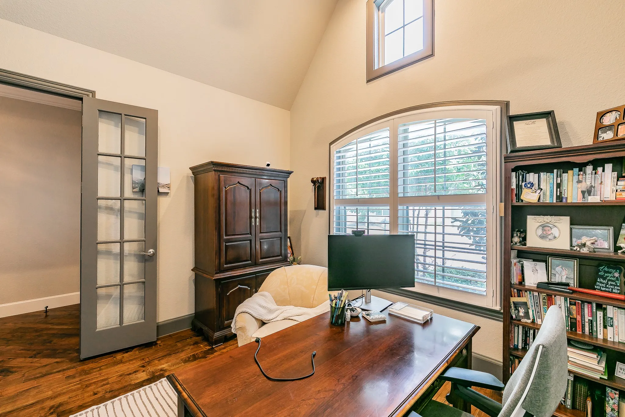 Hardwood flooring, arched window, secondary upper window, French doors.