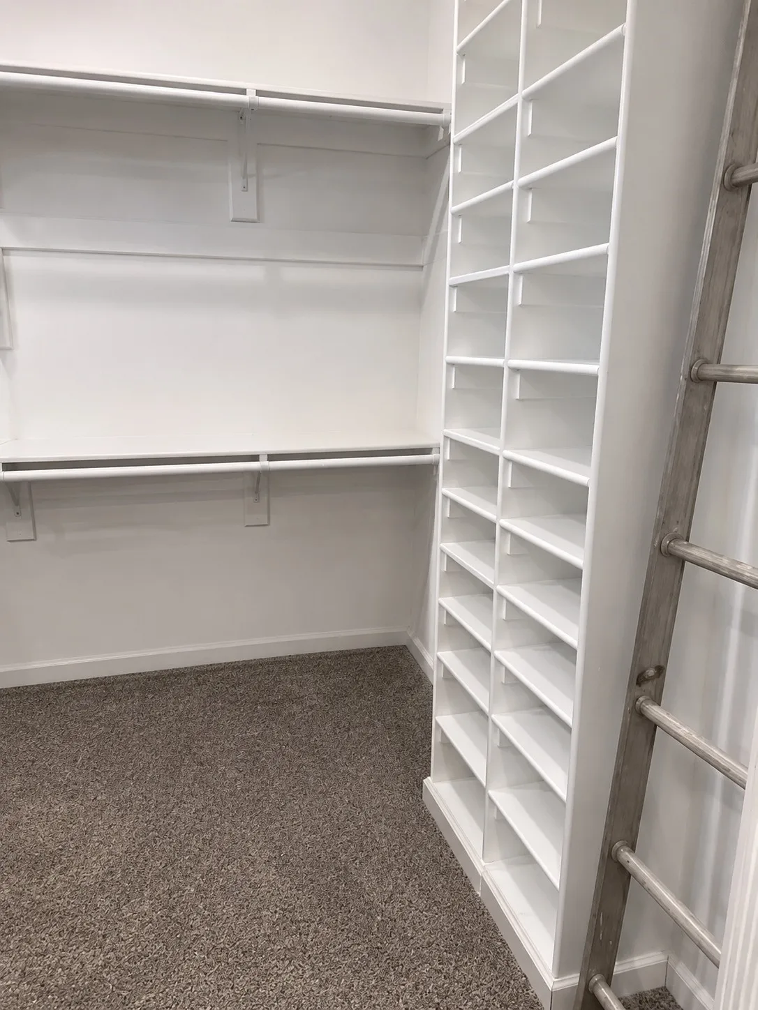 Built-in shelving, two levels of hanging rods, and carpet flooring