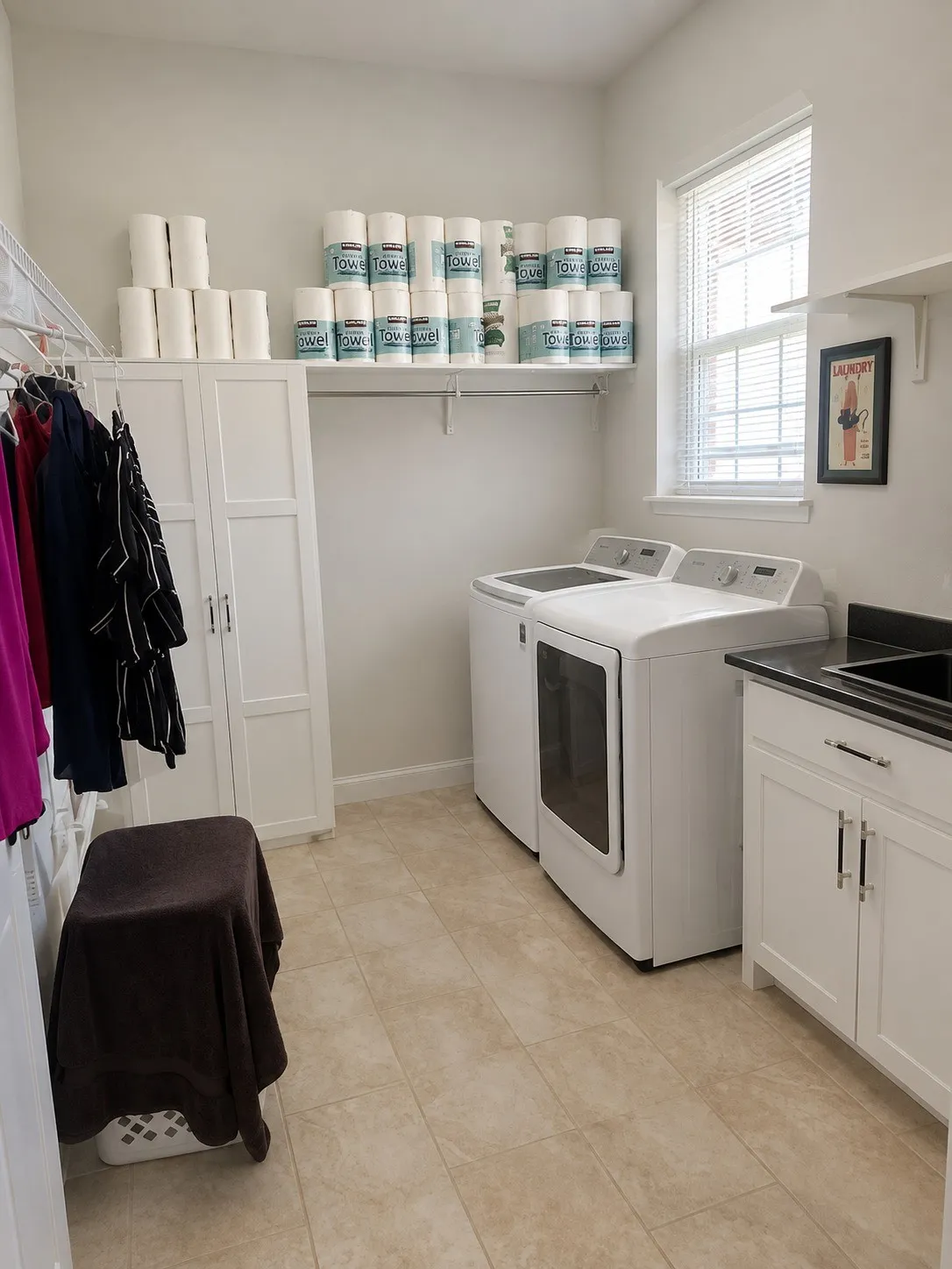 Functional laundry room featuring a built-in white cabinet, overhead shelving, and a window with blinds