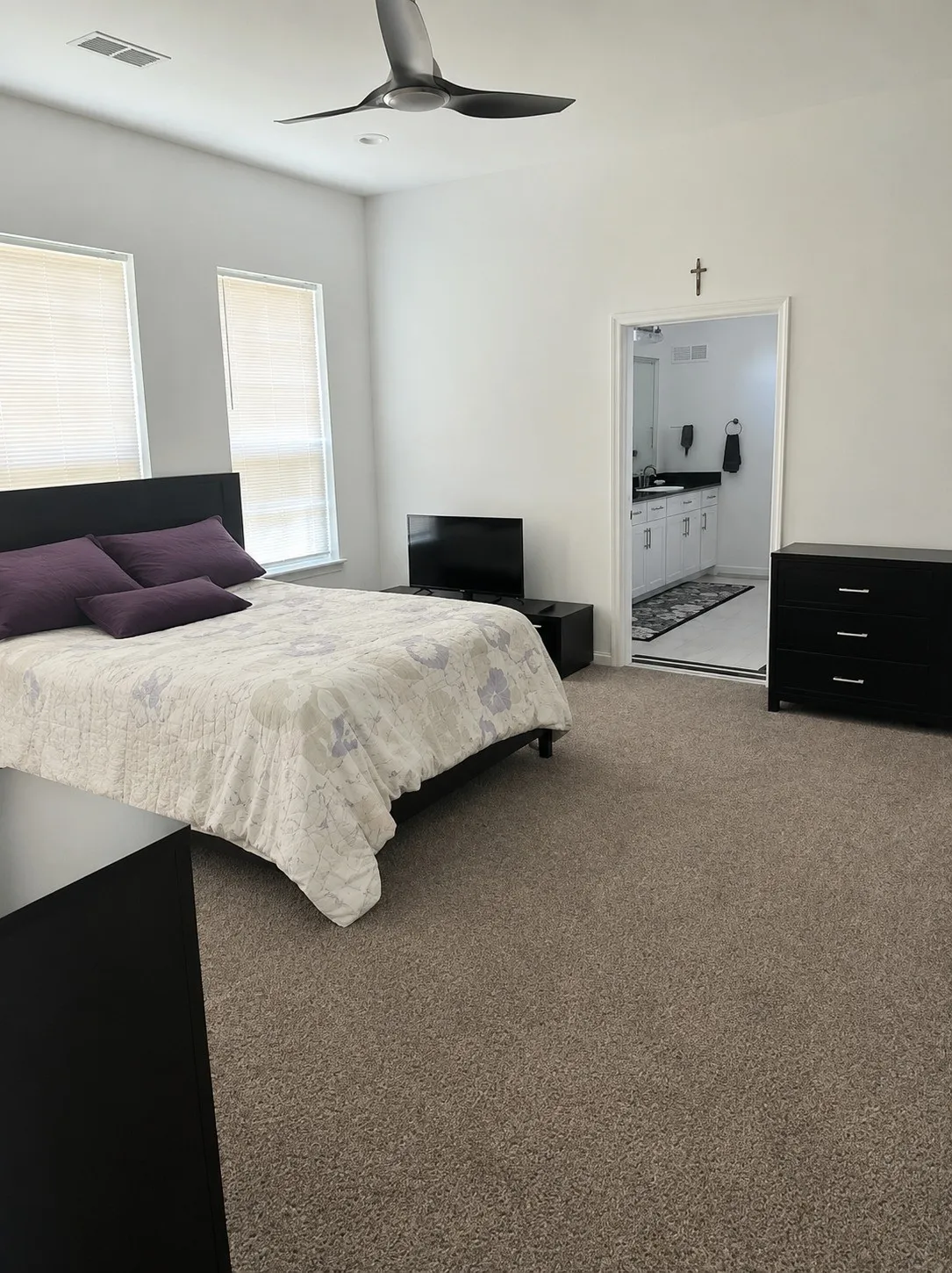 Vaulted ceiling with a contemporary ceiling fan, dual windows with blinds, and carpeted flooring