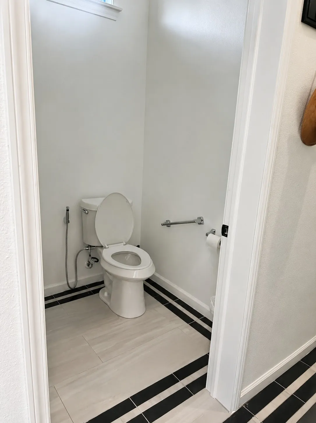 White toilet with an attached bidet sprayer