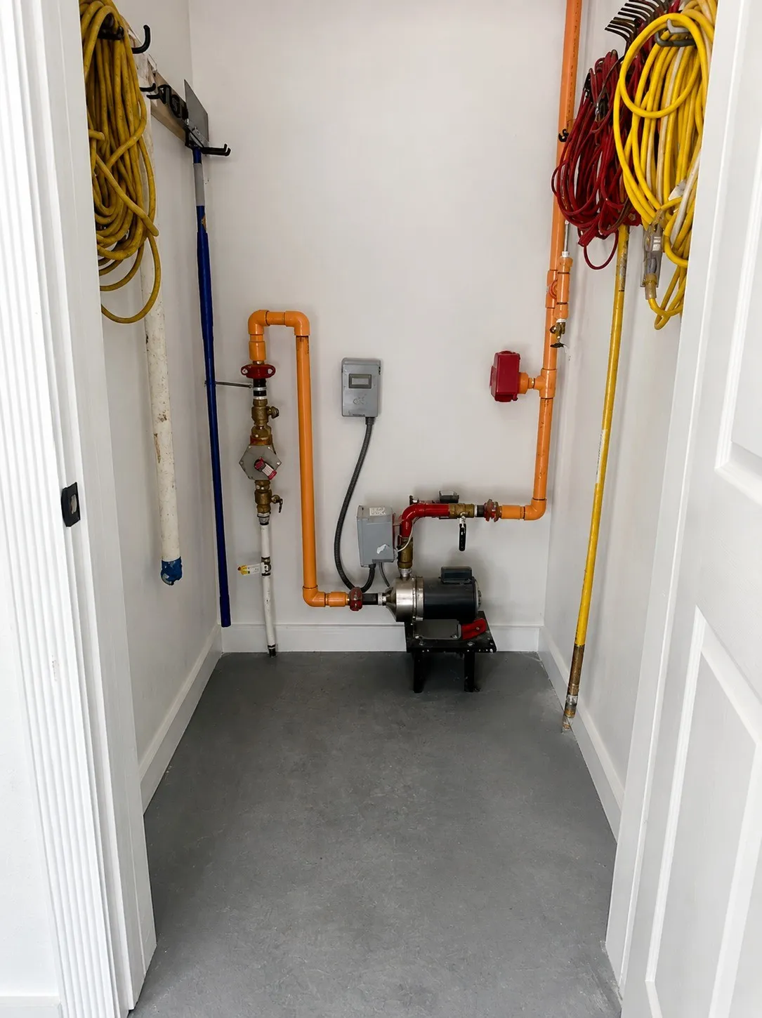 Utility closet with gray flooring and white walls
