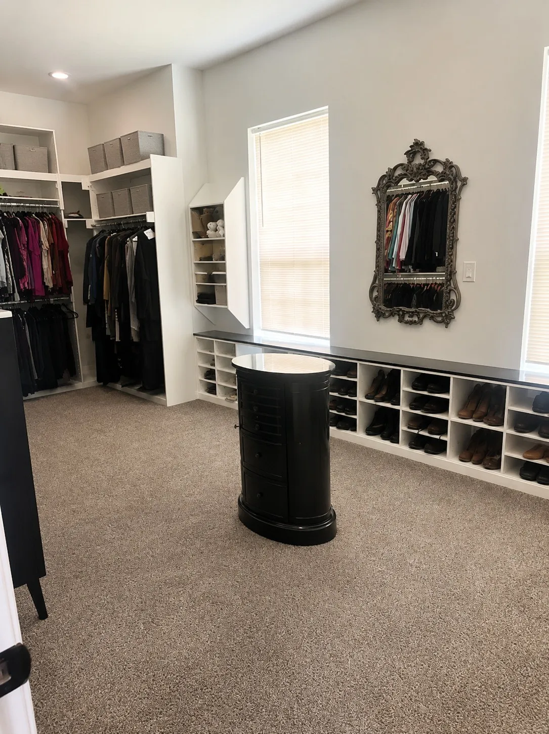 Built-in custom closet system with extensive hanging rods, open shelving, and integrated shoe storage