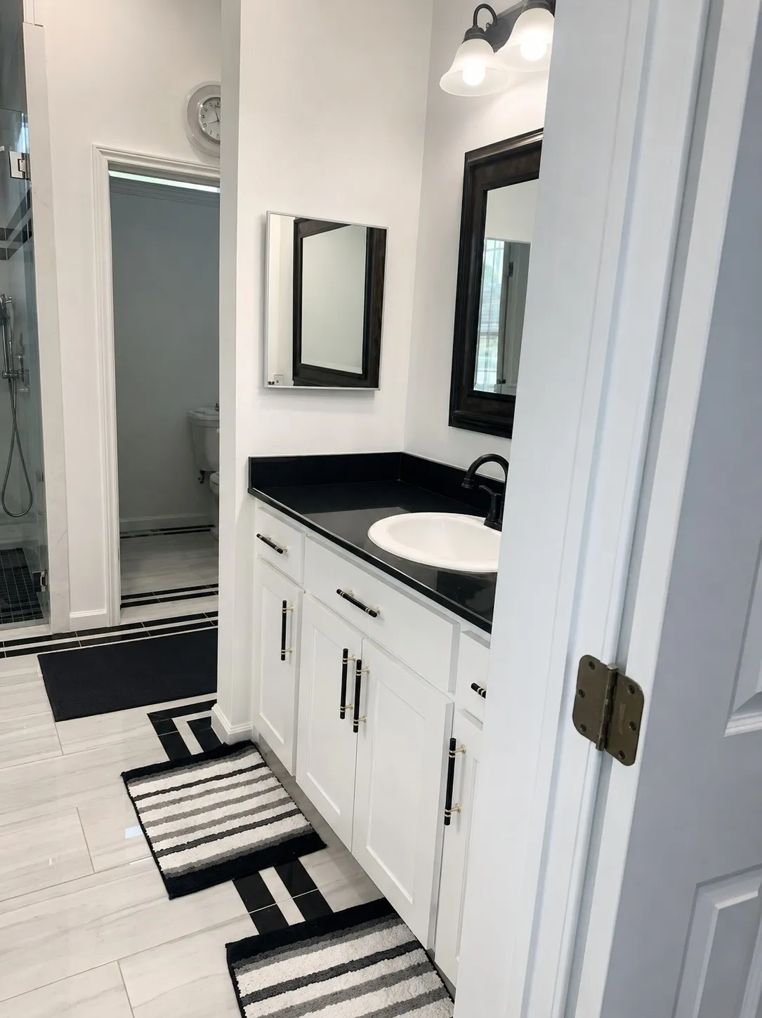 White vanity with black hardware, black countertop, and undermount sink