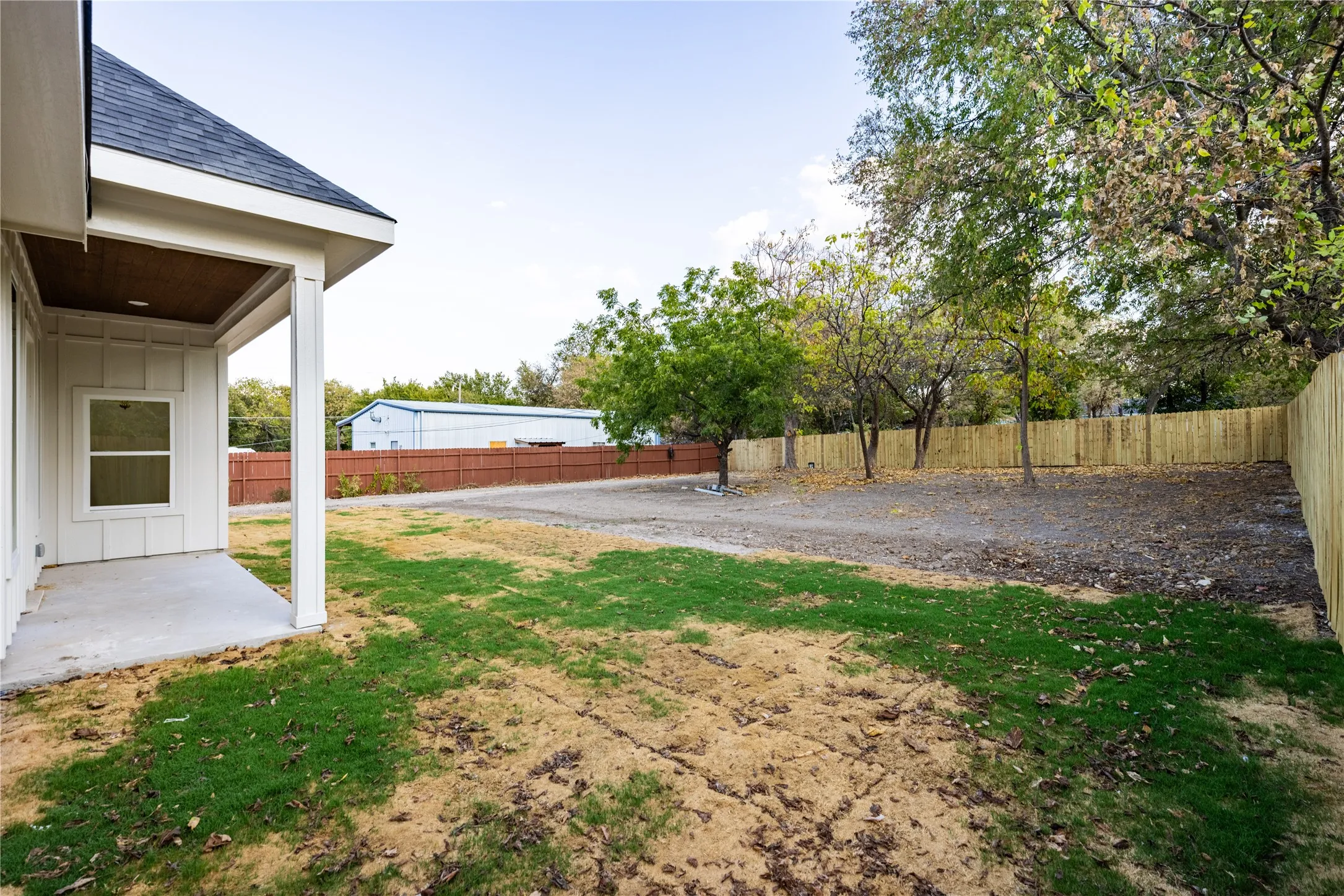 Covered concrete patio with white siding exterior