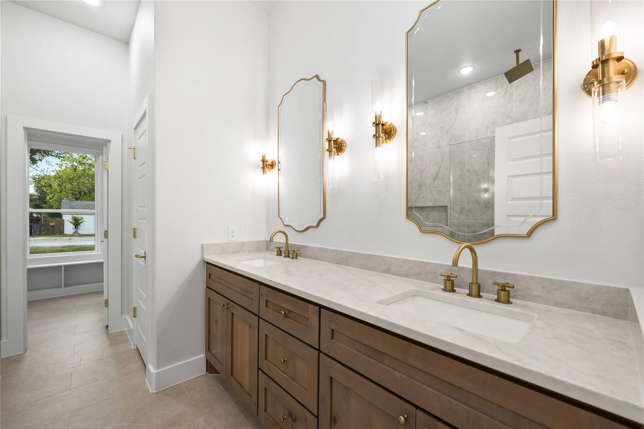 Dual vanity with stone-finish countertop, undermount sinks, and brass-finish fixtures