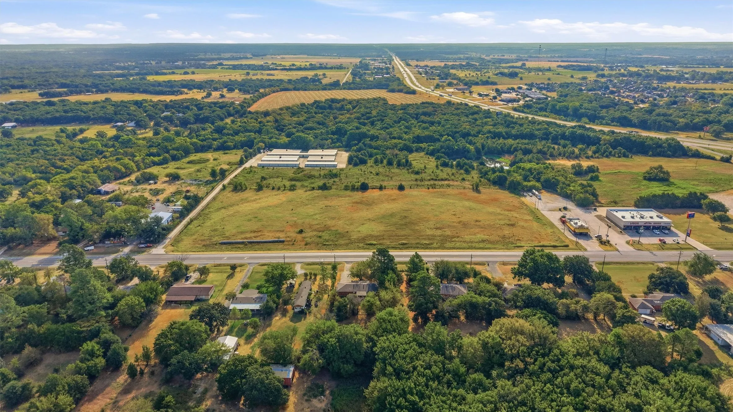 Expansive land parcel with surrounding commercial development, adjacent to a major roadway