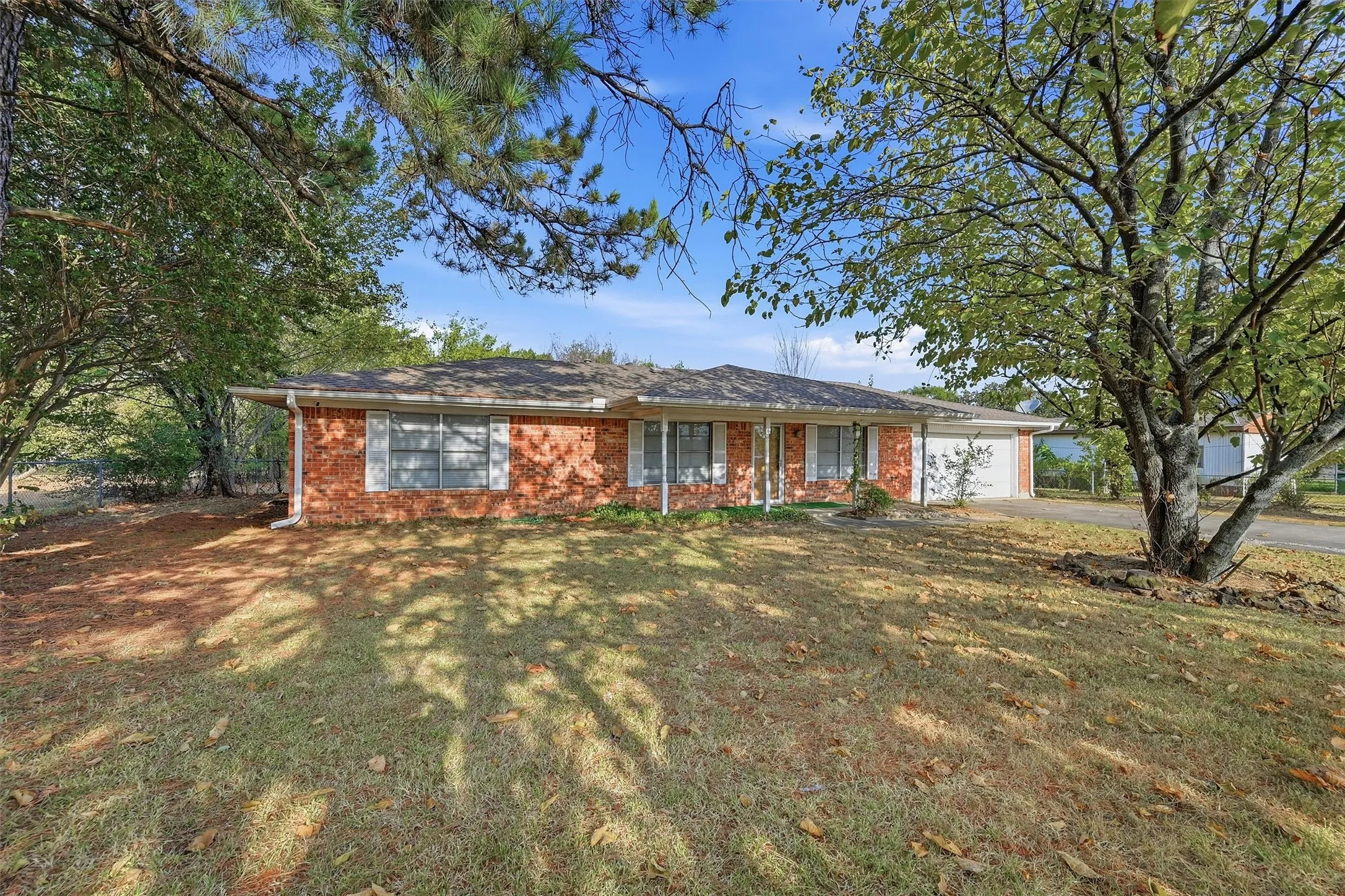 Brick exterior with white trim, covered front entry, and attached garage