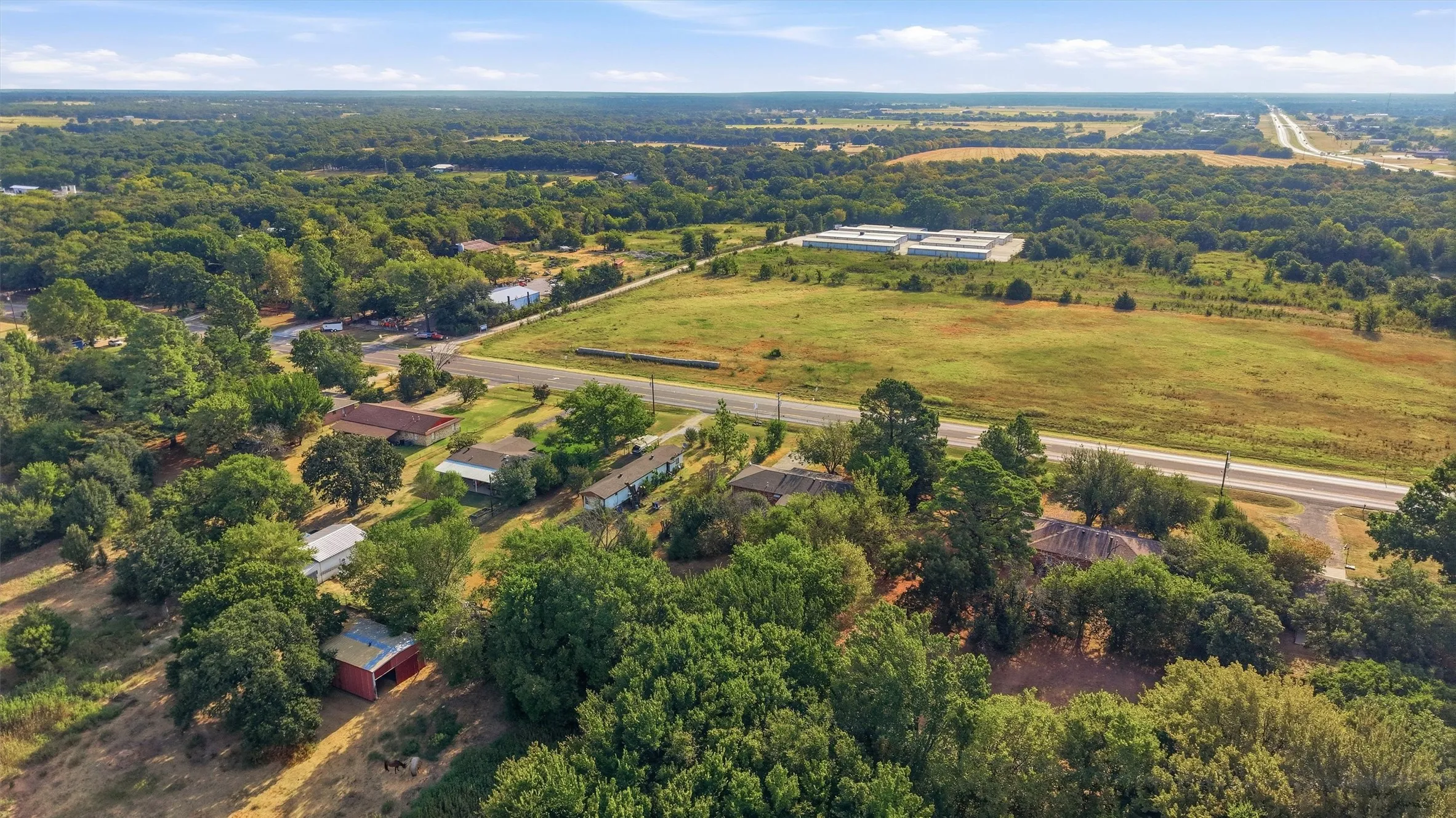 Expansive acreage featuring mature trees and a distant highway